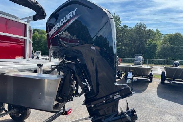 2026 Sun Tracker Party Barge 20 DLX with Mercury outboard motor in a parking lot.