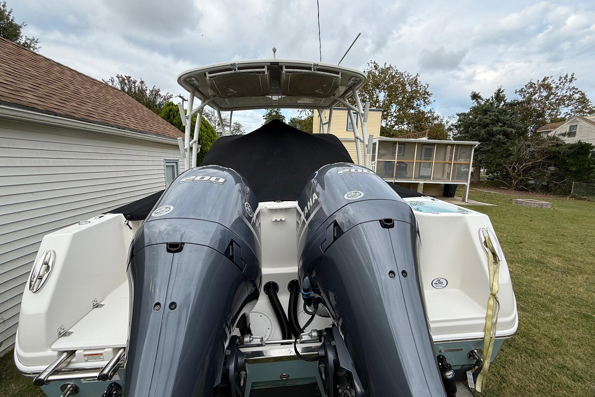 2019 Sailfish 275 DC boat with dual Yamaha outboard motors in a backyard setting.