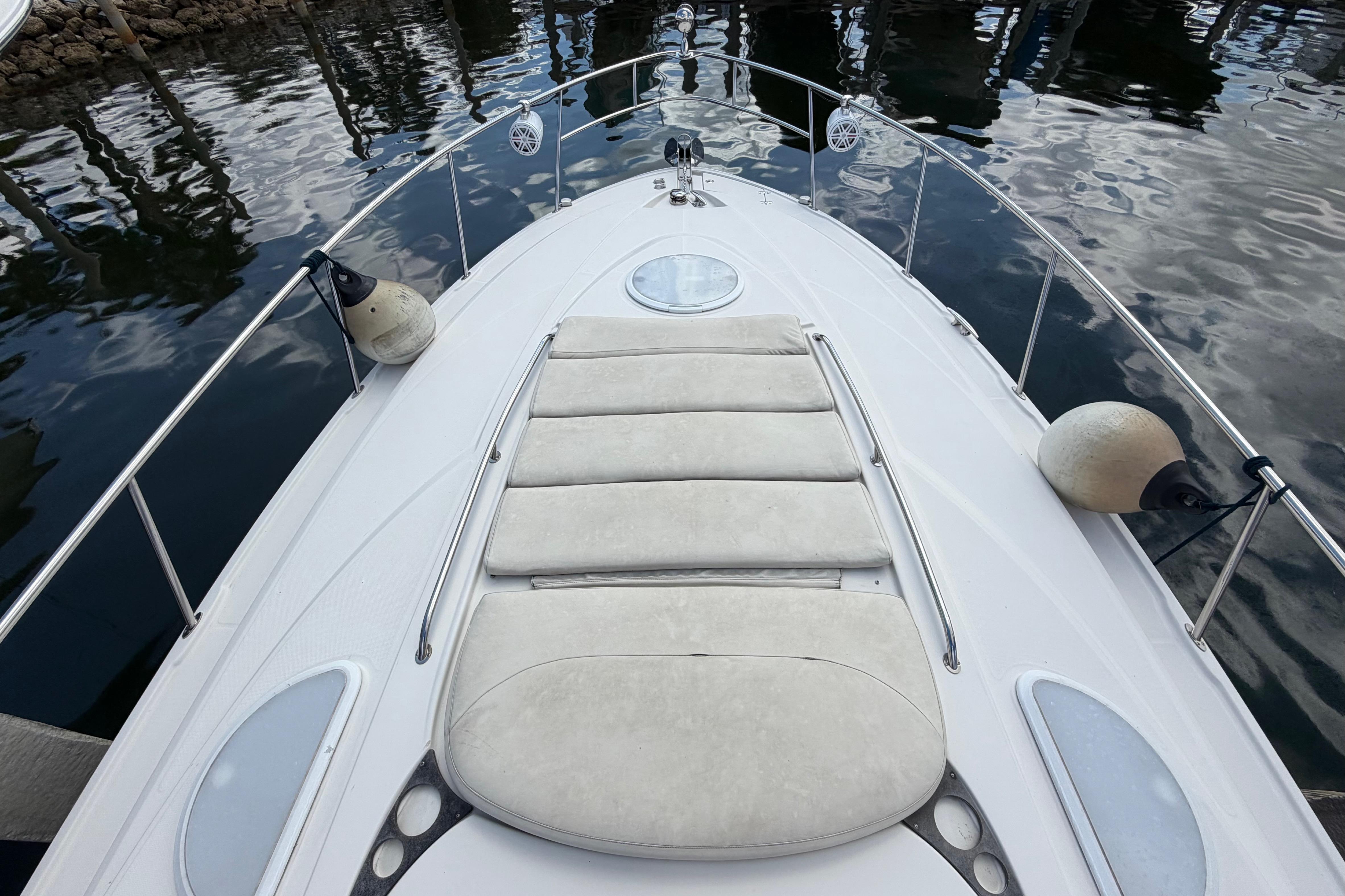 Bow view of 2007 Monterey 350 Sport Yacht with sunpad and railings, docked on calm water.