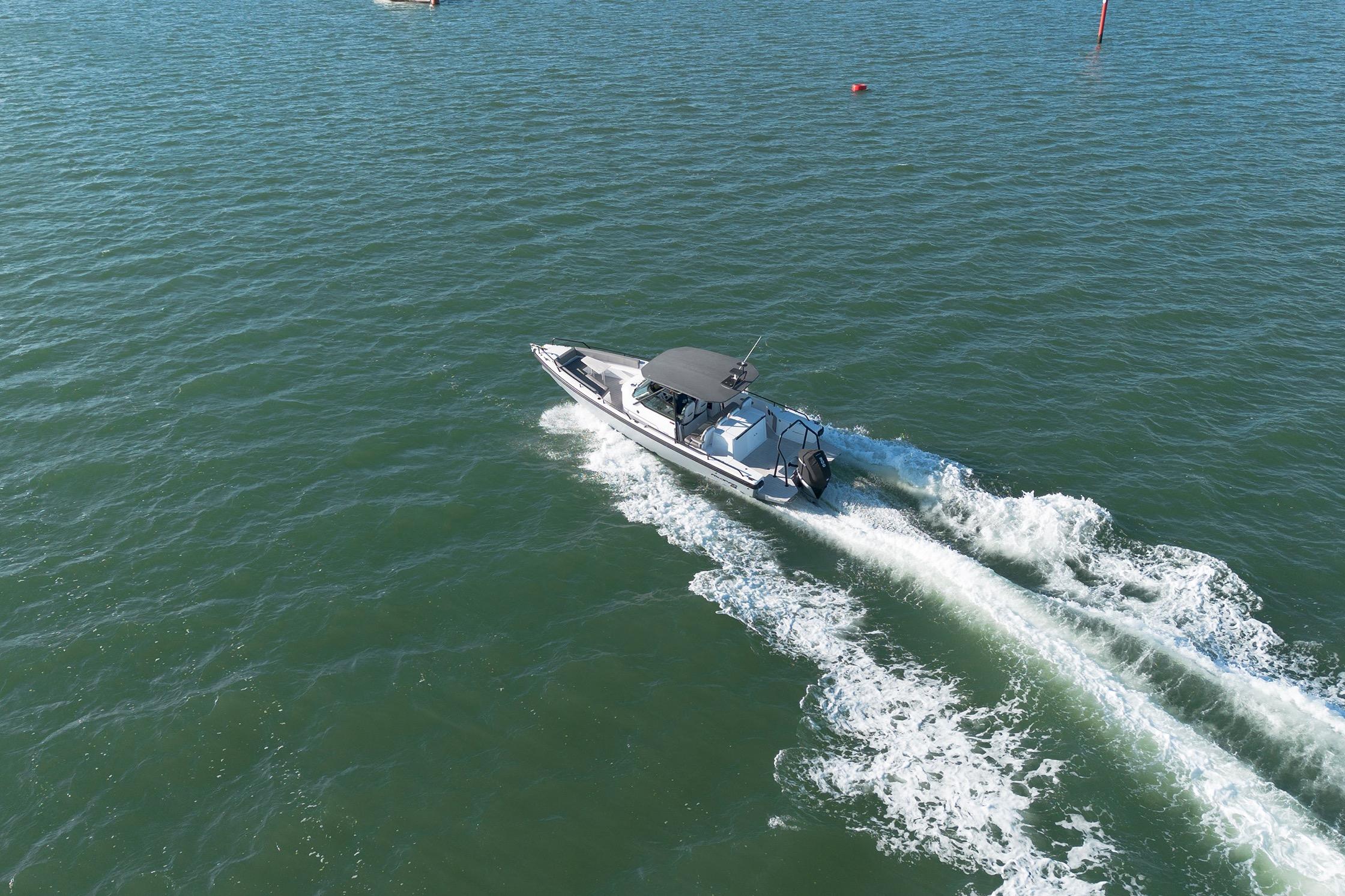 2019 Axopar 28 T-Top boat cruising on open water, creating a wake.
