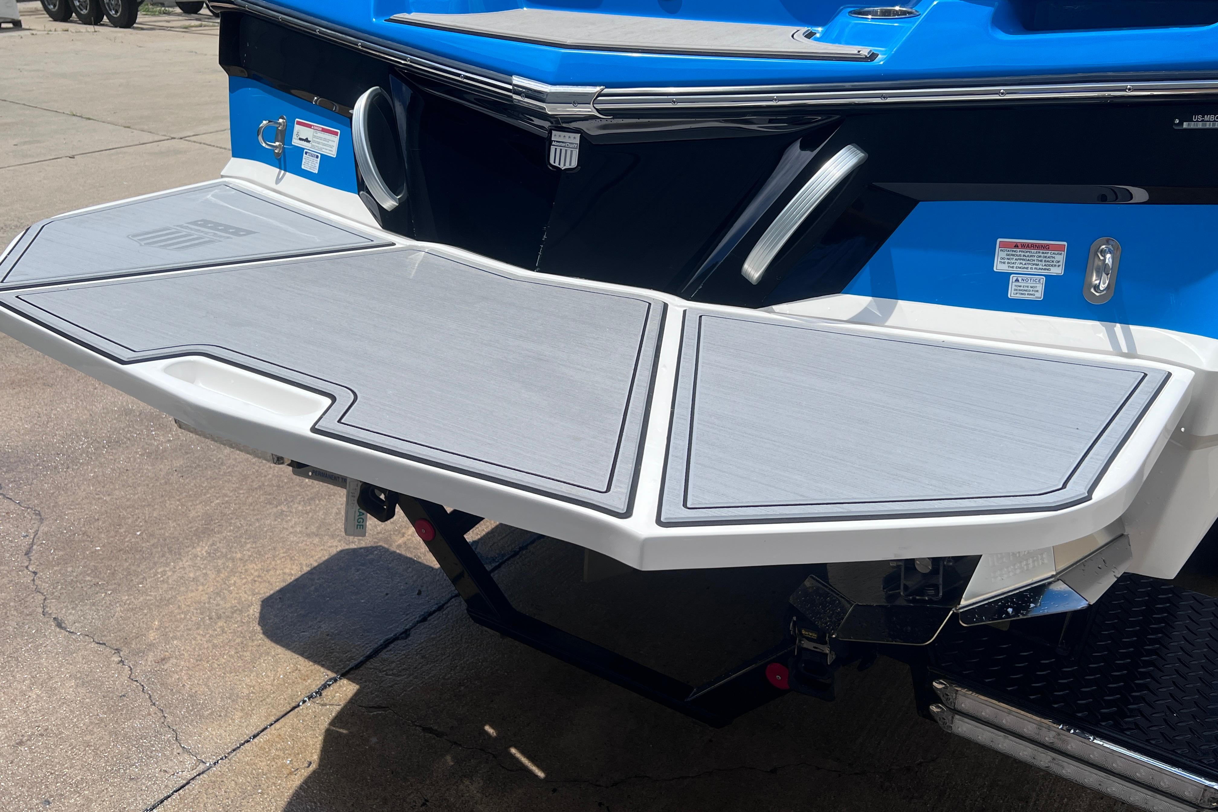2021 MasterCraft XT23 boat with sleek swim platform and blue exterior.