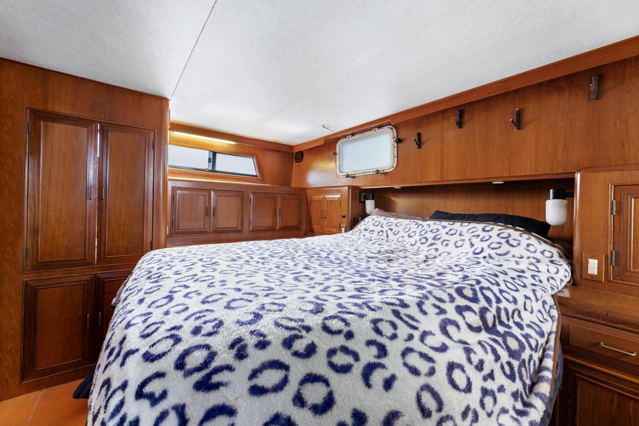 1988 Marine Trader Trawler cabin with cozy bed and wooden interior design.