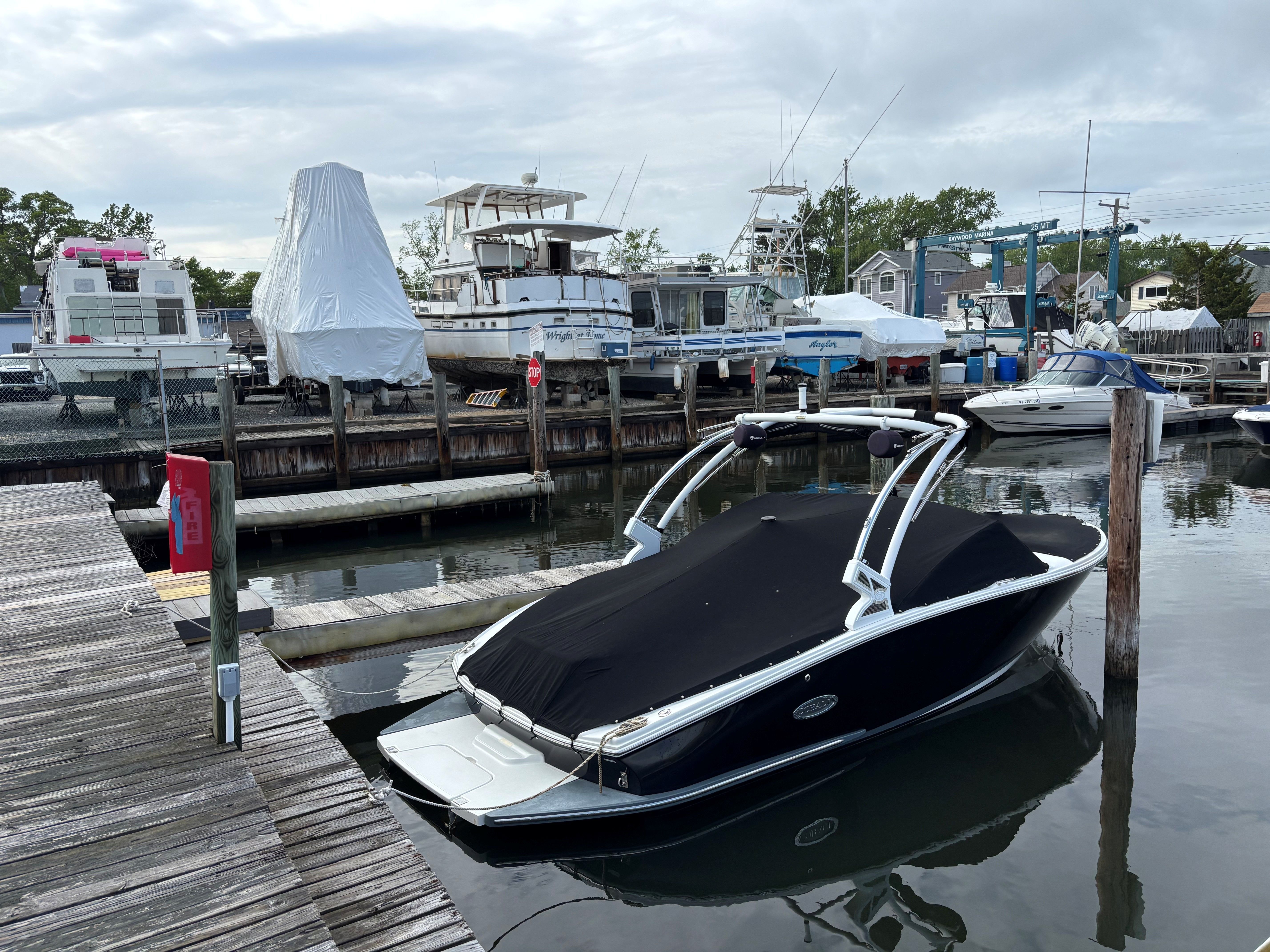 A 2019 Cobalt CS22 boat is docked in a calm marina, surrounded by other boats.