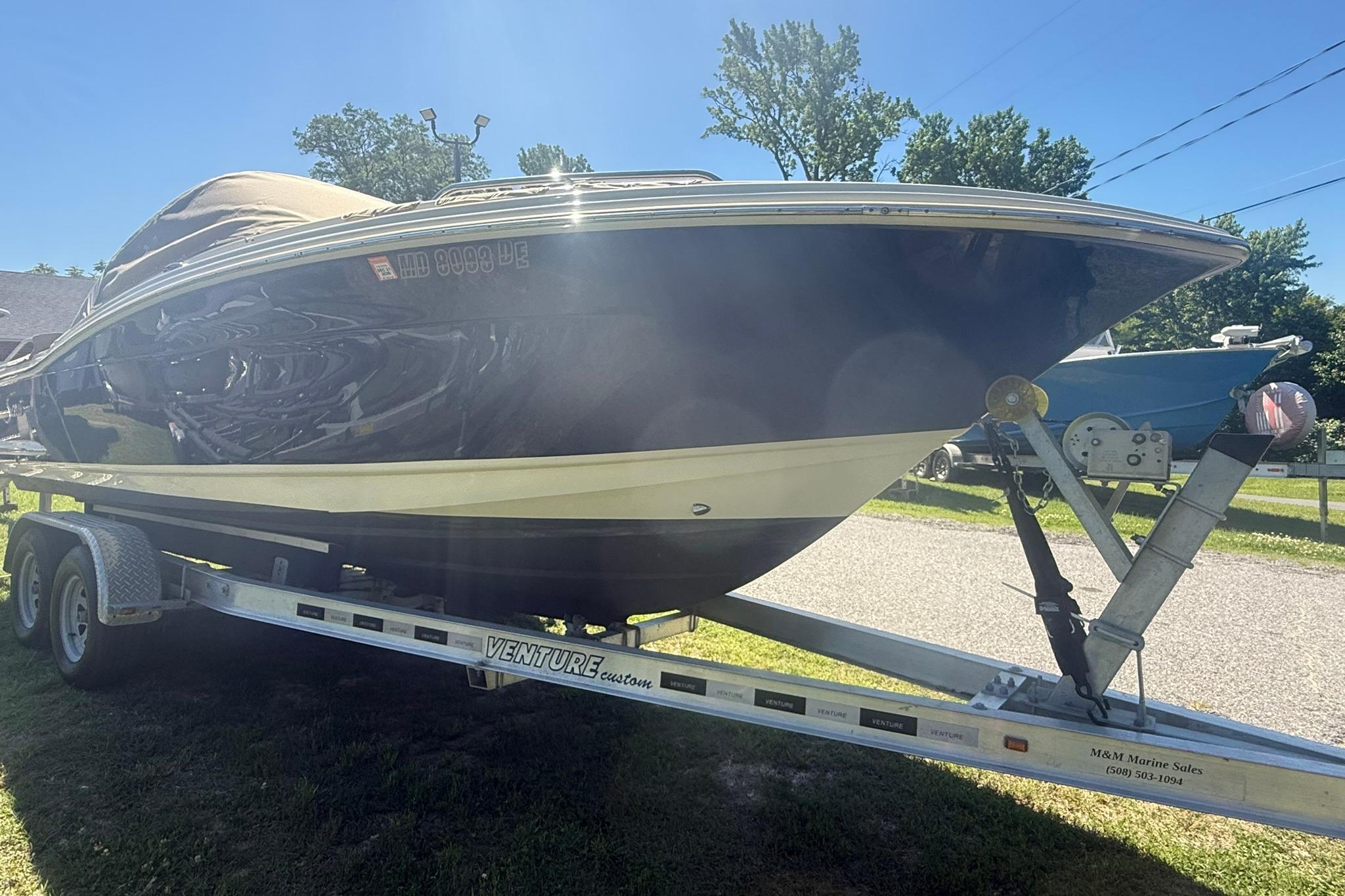 2021 Scout 215 Dorado boat on trailer, parked outdoors under clear sky.