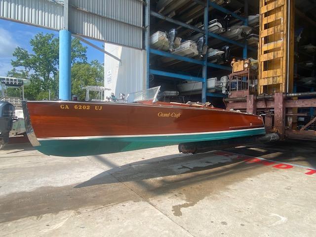 A 2000 Grand Craft Classic Runabout boat in a storage facility.