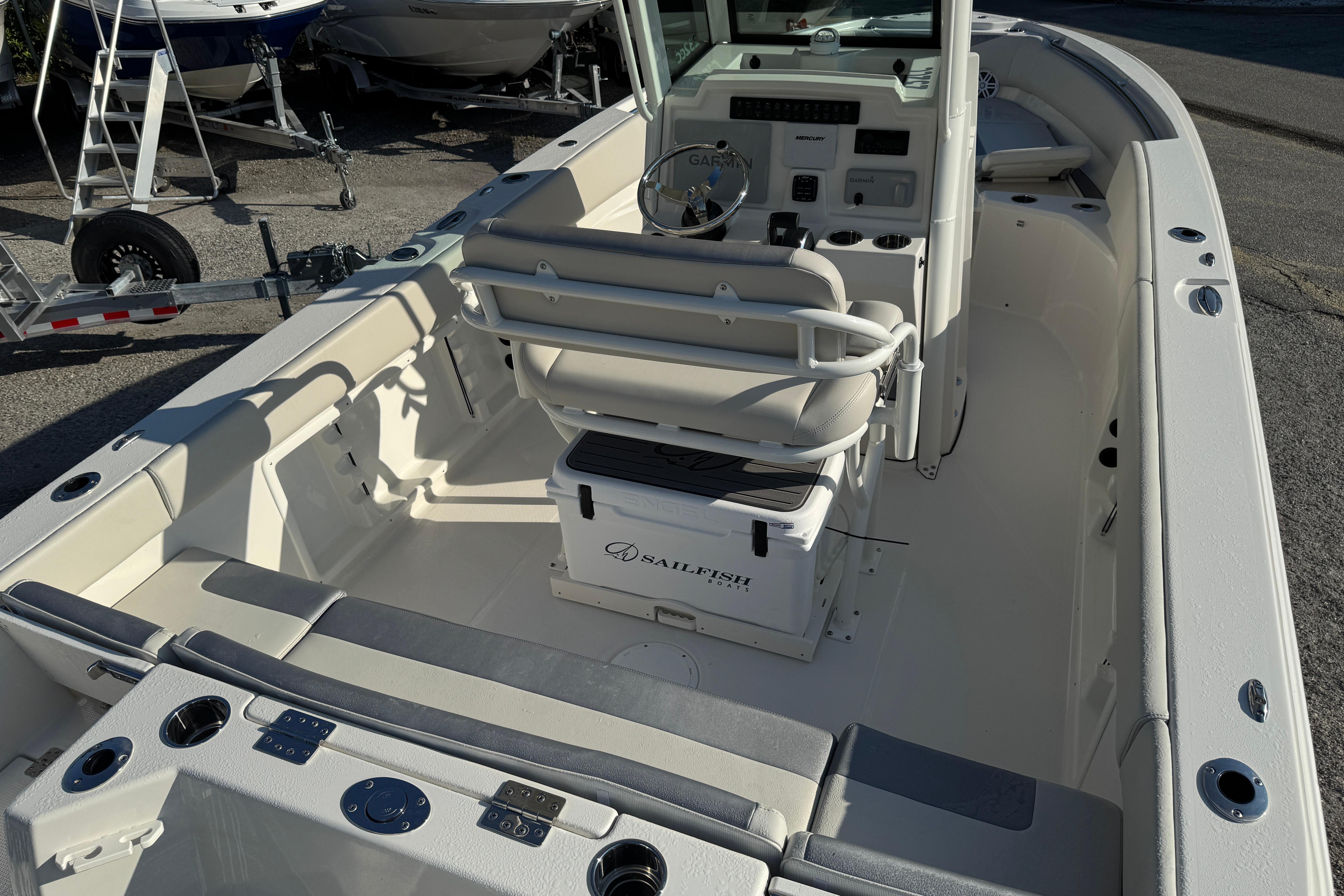 2026 Sailfish 232 CC boat interior with helm, seating, and storage, parked on a trailer.