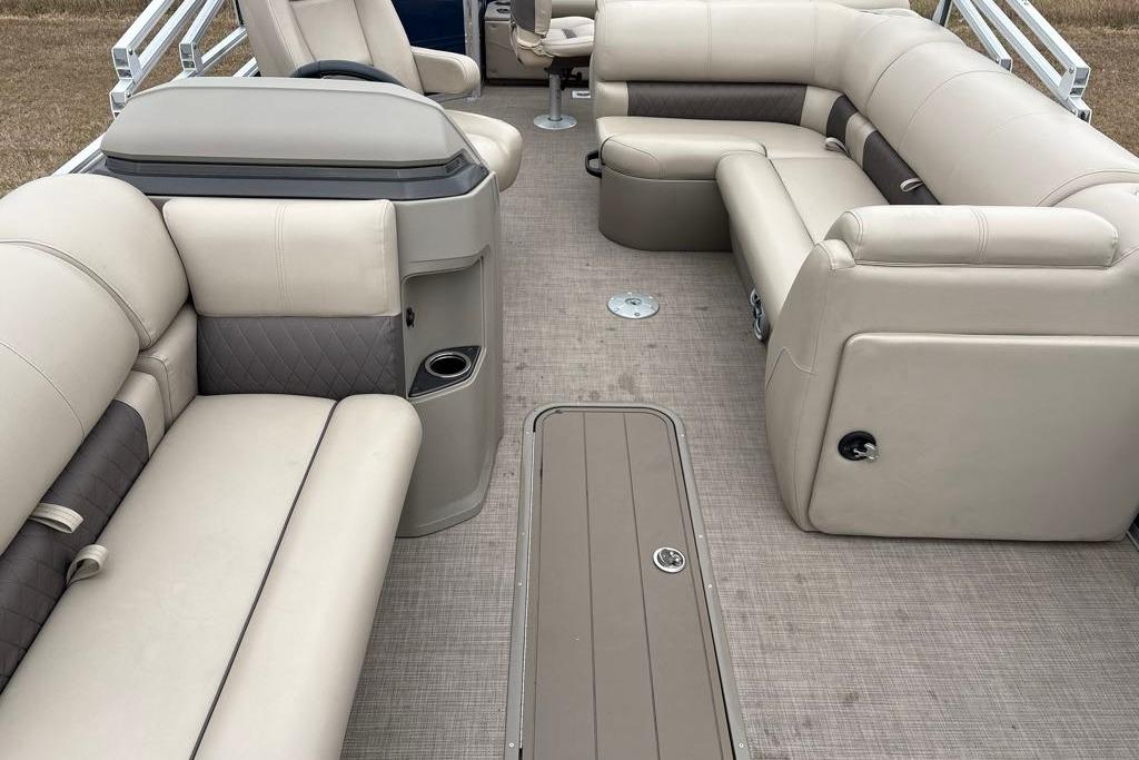 2025 Sun Tracker Fishin' Barge 22 XP3 interior with beige seating and spacious layout.