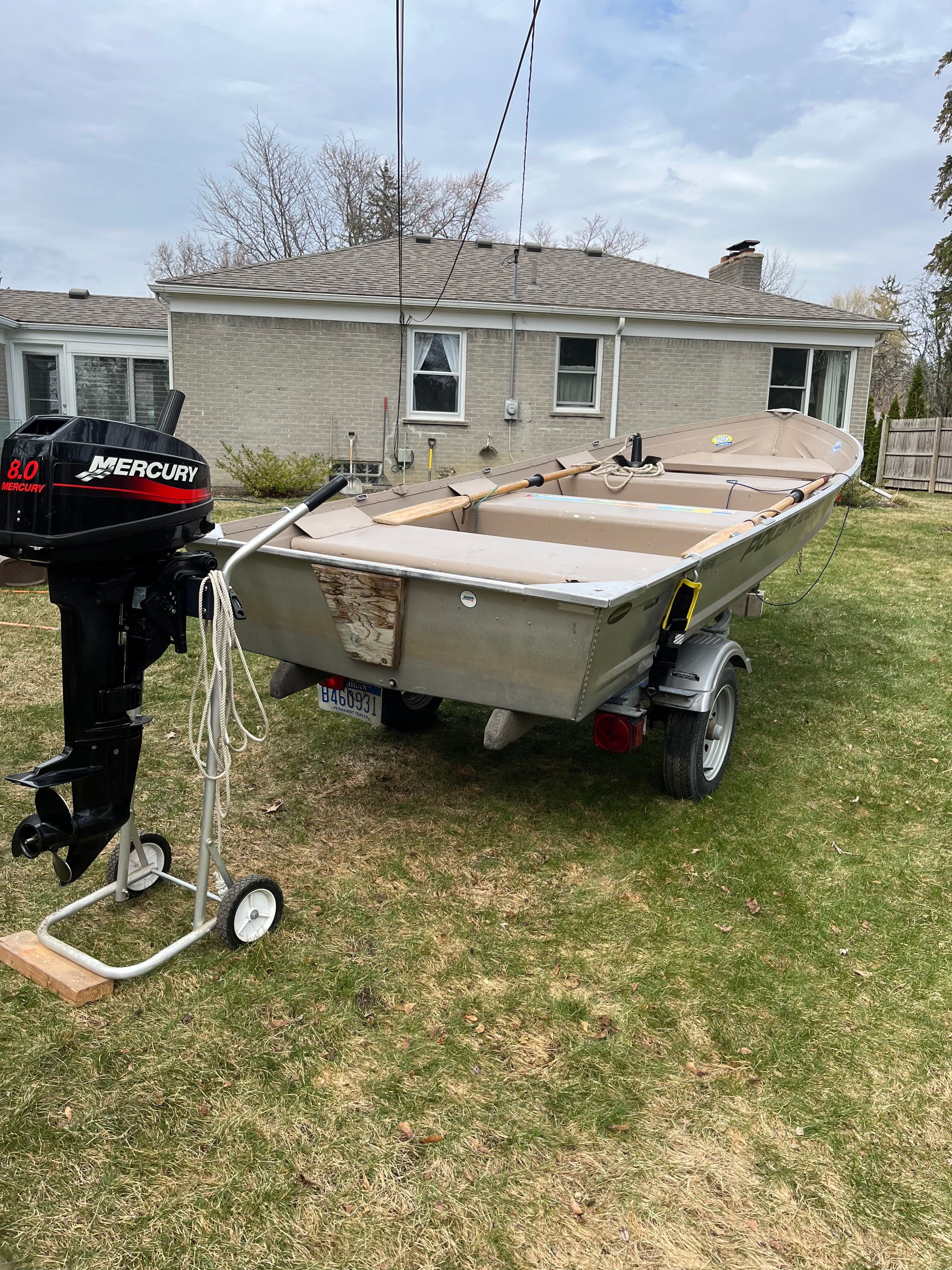A 2005 Polar Kraft V1460 boat on a trailer in a backyard.