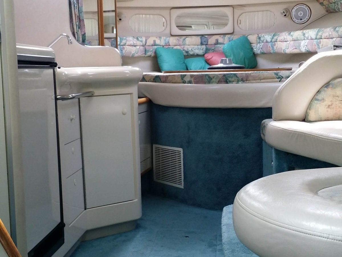 Interior of a 1995 Sea Ray Sundancer 330 with seating area and kitchenette.