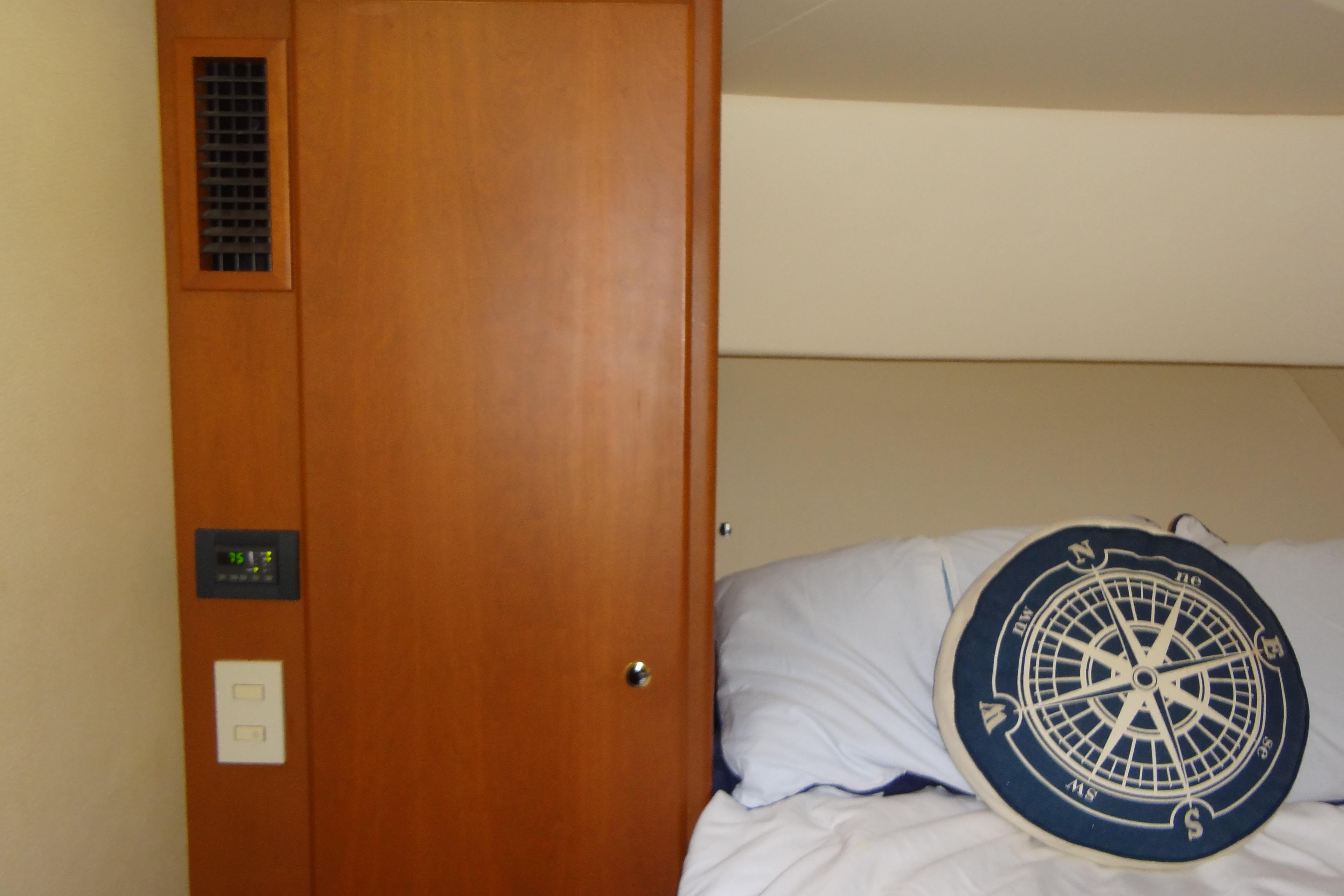 Interior of 2005 Silverton 34 Convertible with nautical-themed pillow and wooden paneling.