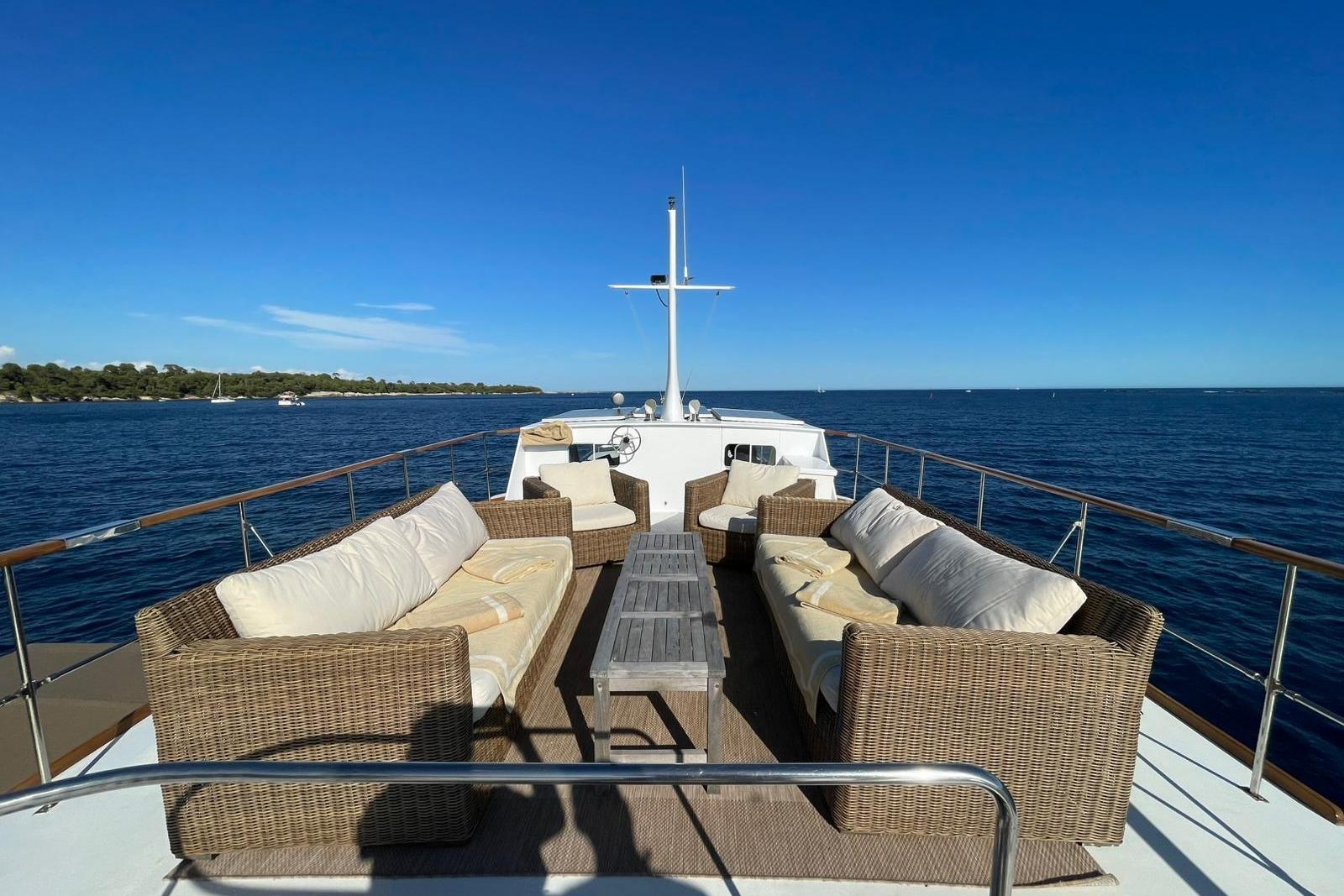 Luxury seating area on 1971 Dagless Ambassador yacht, overlooking serene ocean and clear blue sky.