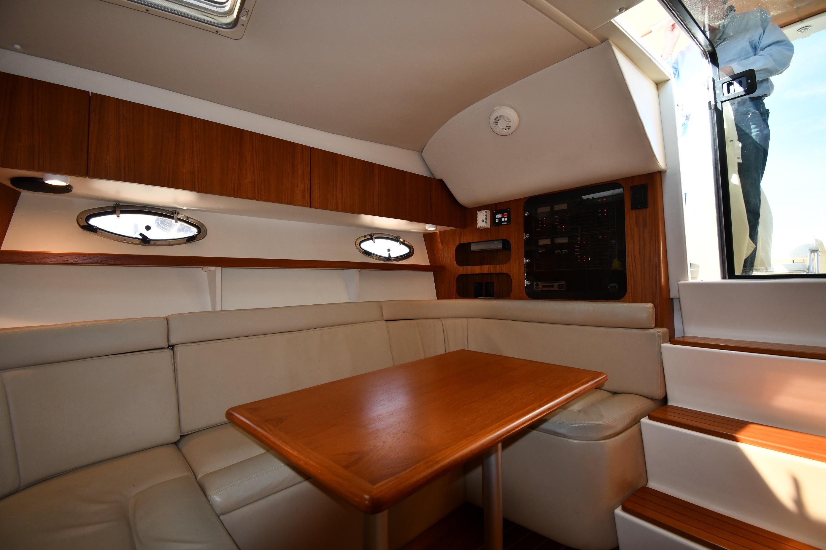 Interior of 1998 Tiara Yachts 3100 Open, featuring a cozy seating area and wooden table.