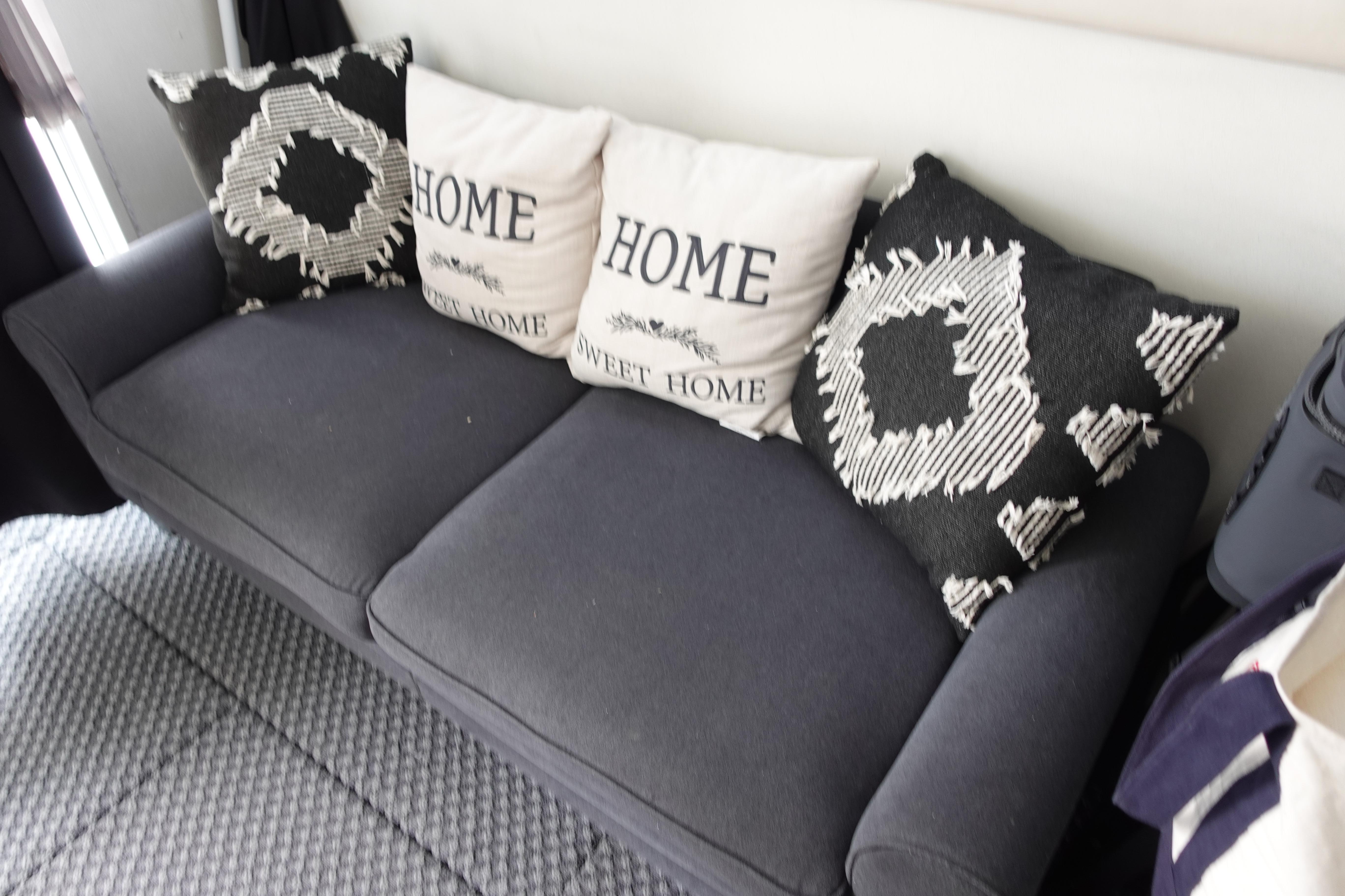Gray sofa with patterned and "Home Sweet Home" pillows, inside 1993 Silverton 31 Convertible.
