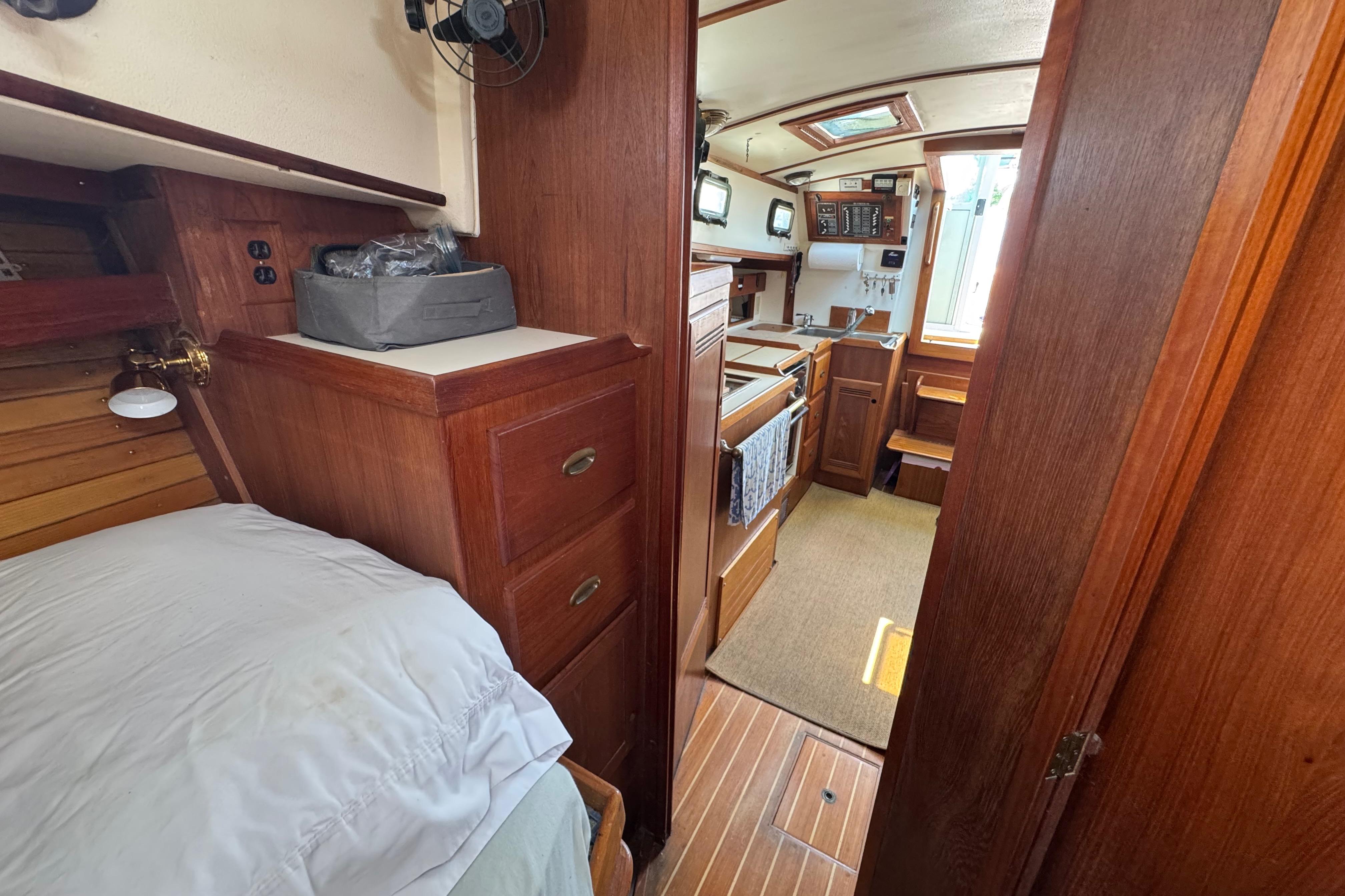 Interior of 1989 Cape Dory 30 Motorsailer with wood finish and compact kitchen.