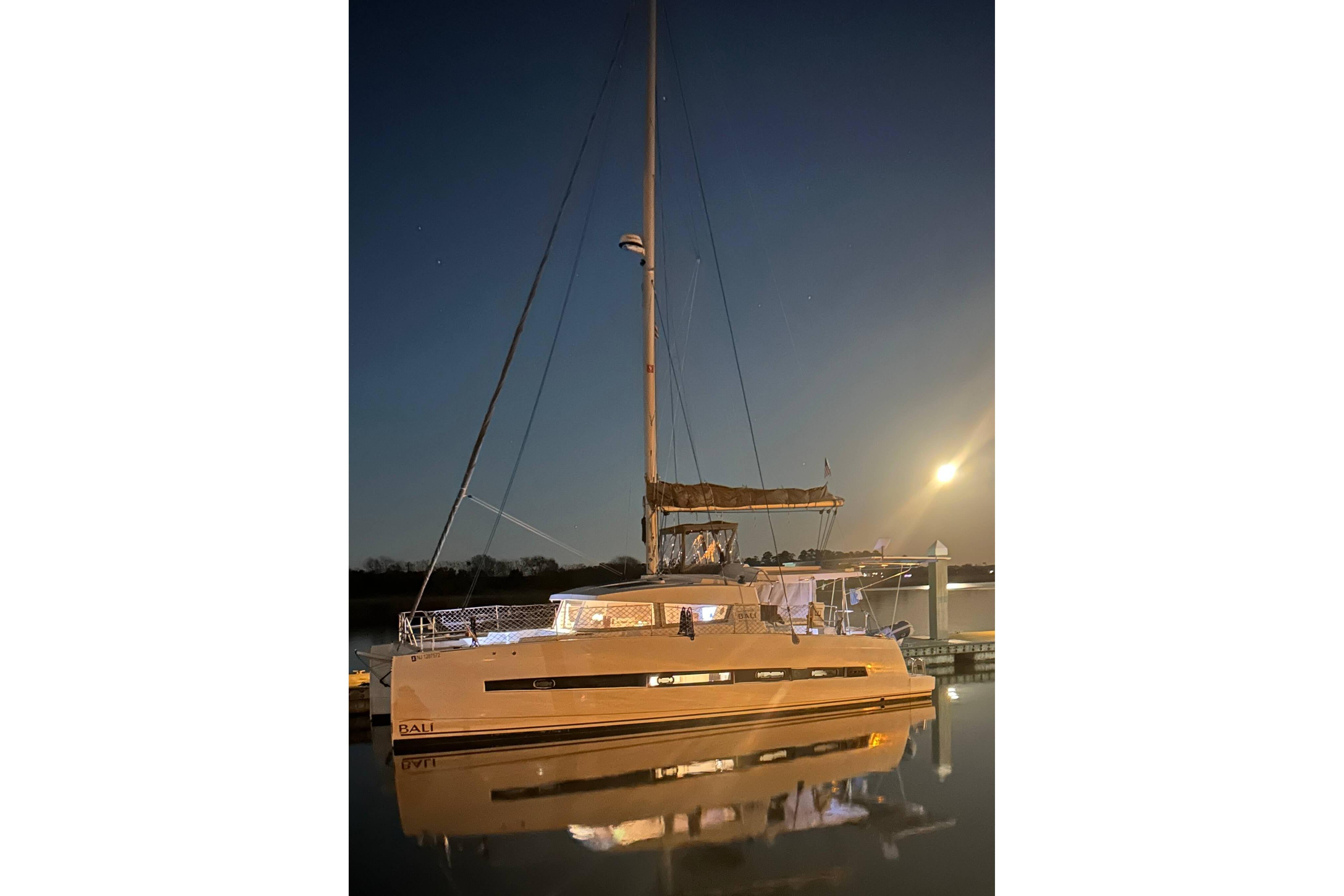 2018 Bali 4.1 catamaran docked at night under moonlight.