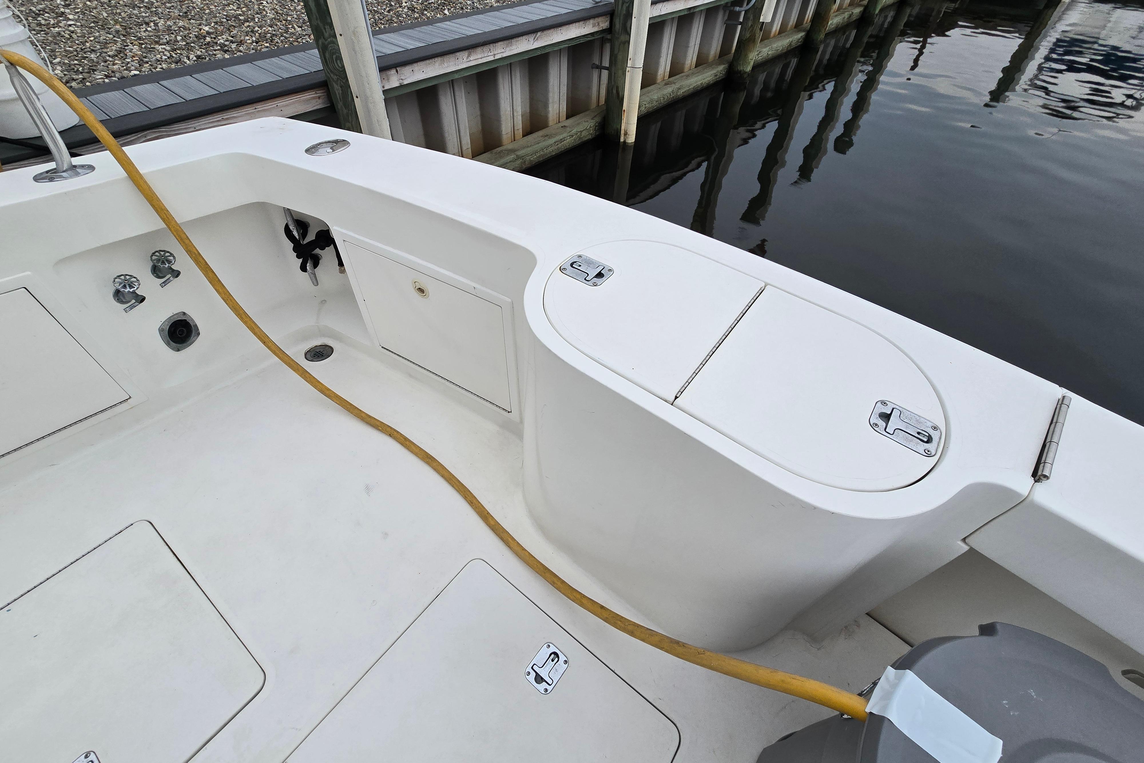 2001 Cavileer 53 Convertible boat deck with storage compartments and hose.