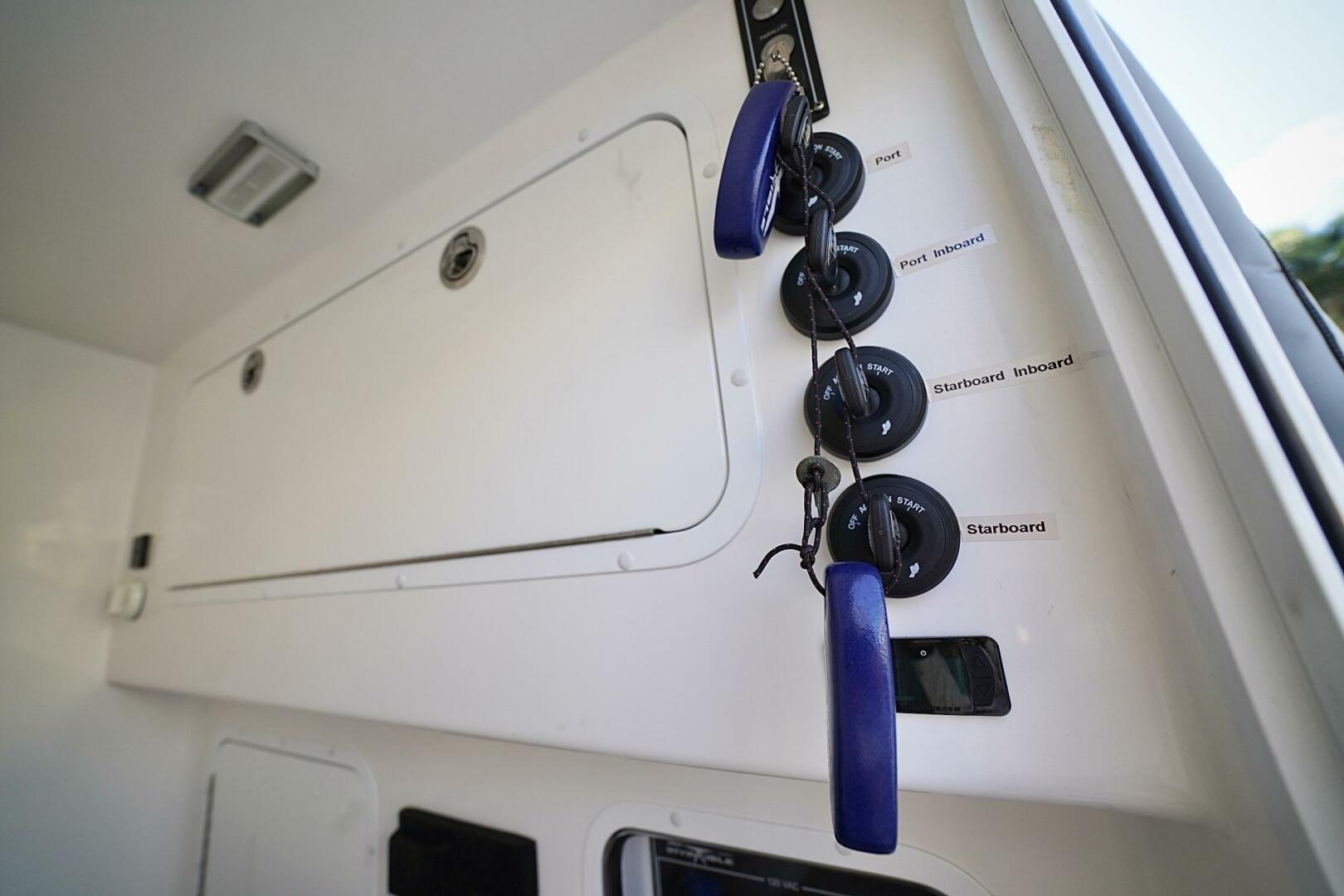 2024 Invincible 35 Catamaran control panel with labeled ignition switches and keys.