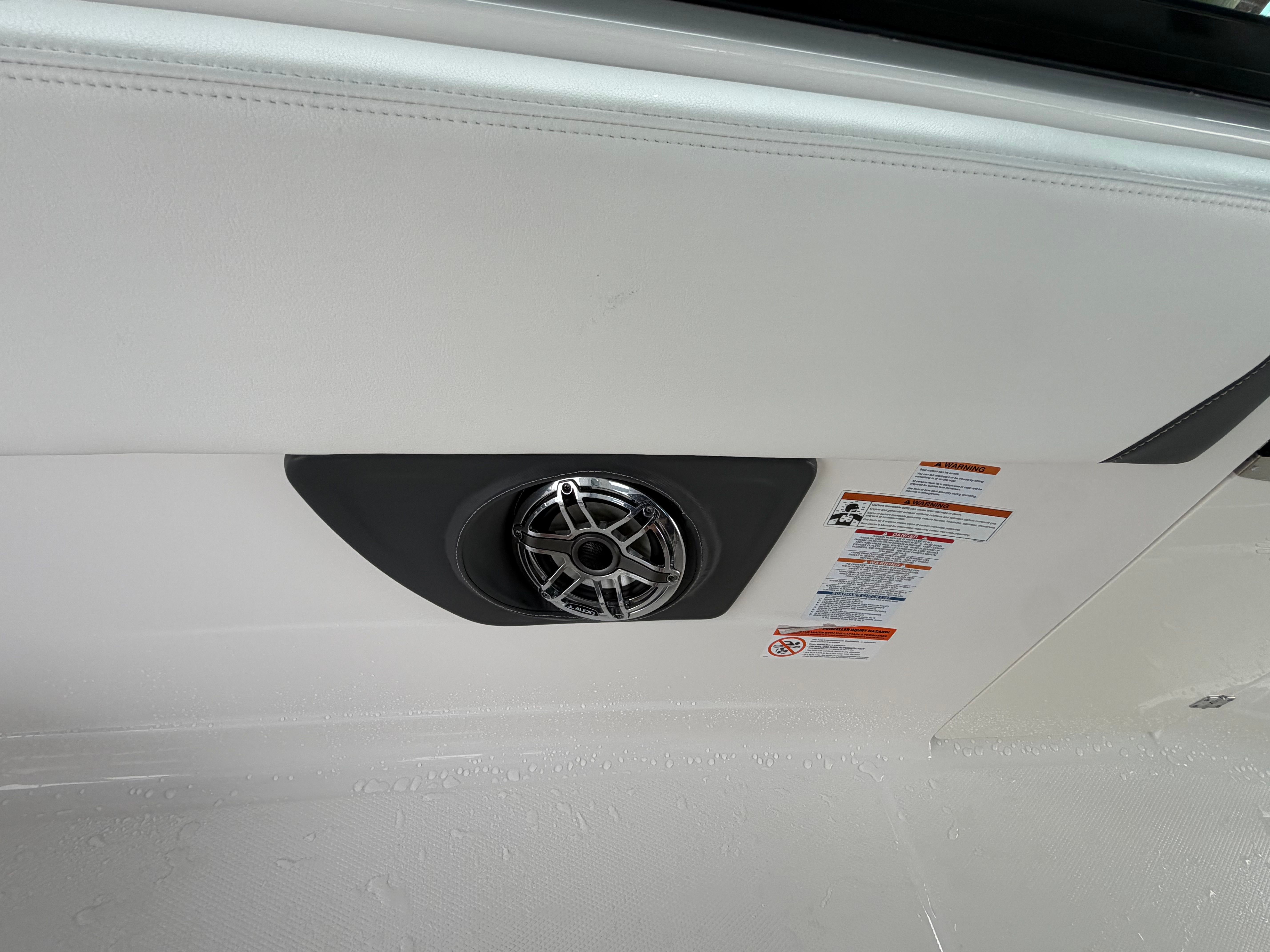 Close-up of a speaker in a boat with white upholstery.