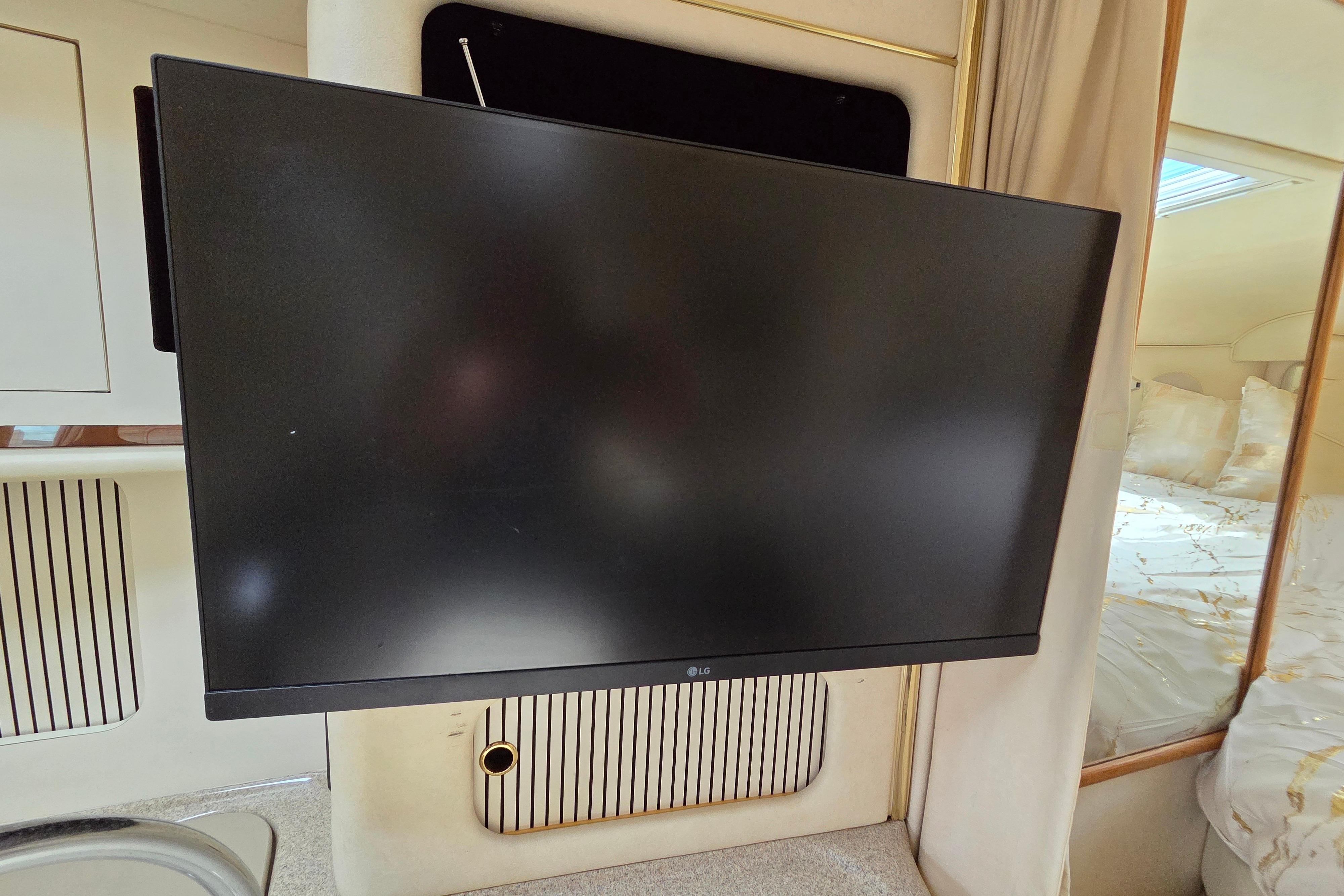 Flat-screen TV inside 2000 Sea Ray 340 Sundancer yacht cabin, near bed and window.