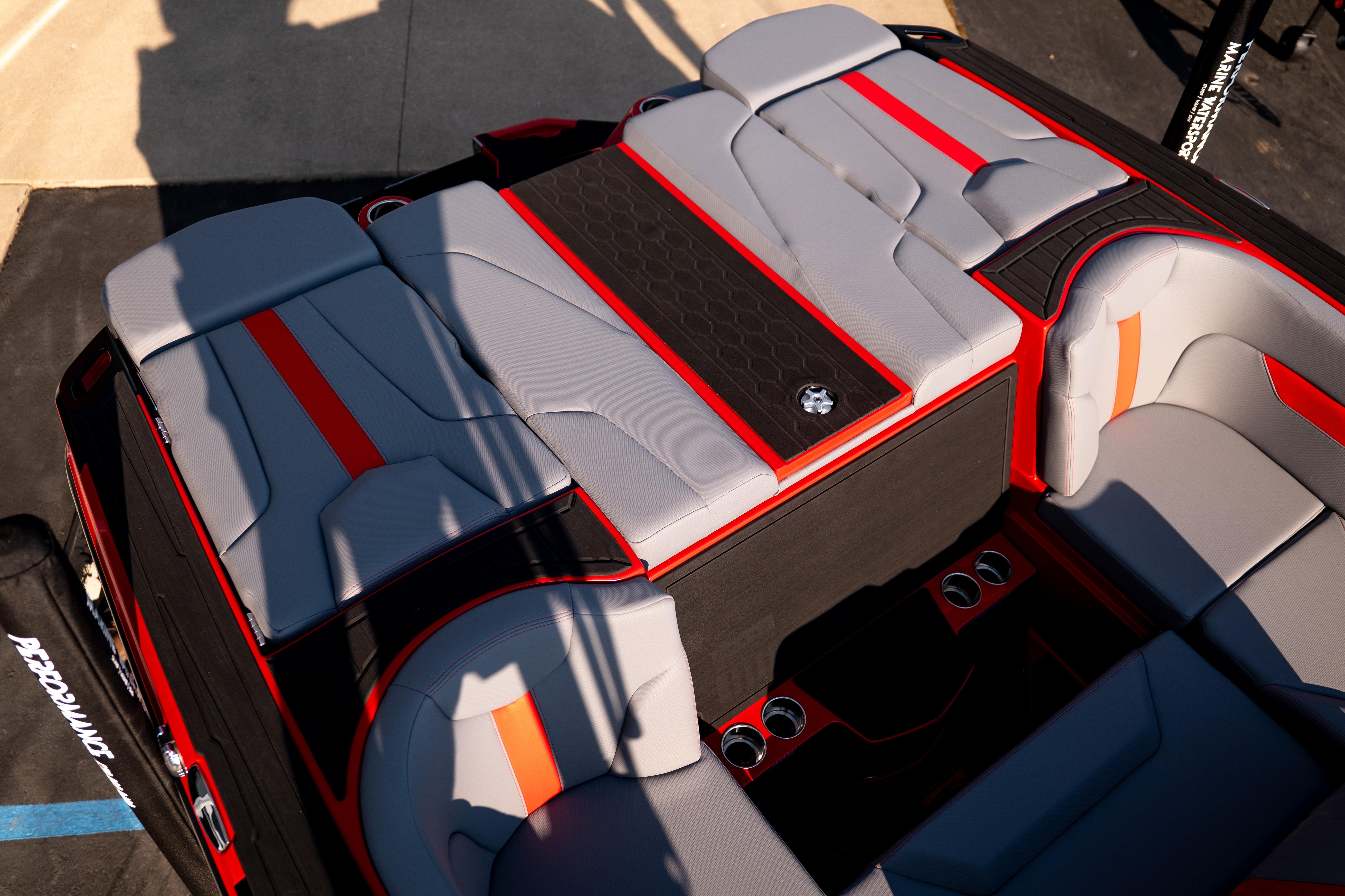 2027 MasterCraft XT24 boat interior with gray and red seating, cup holders, and sleek design.