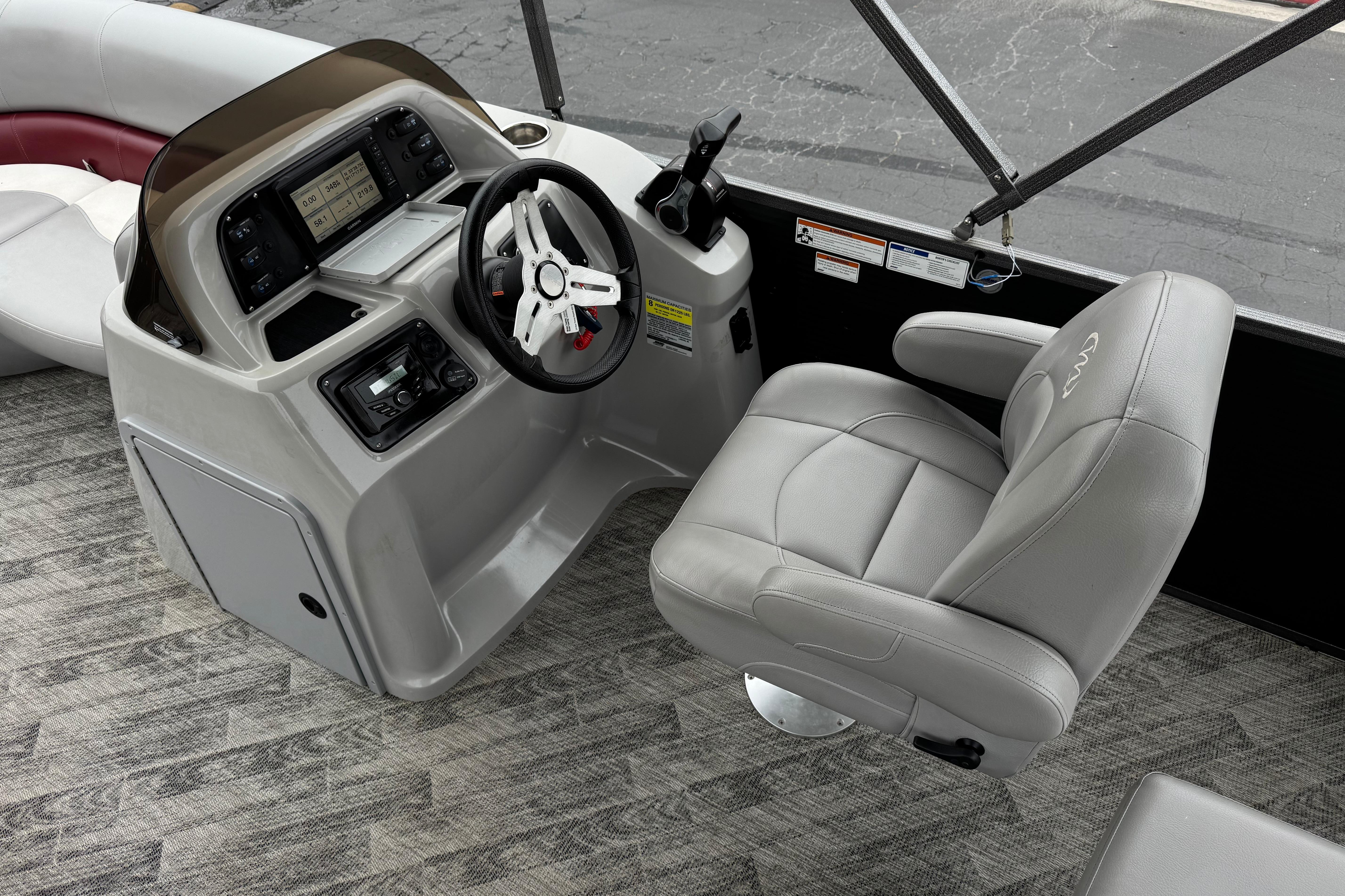 2020 Manitou 18 Aurora LE boat interior with steering console and captain's chair.