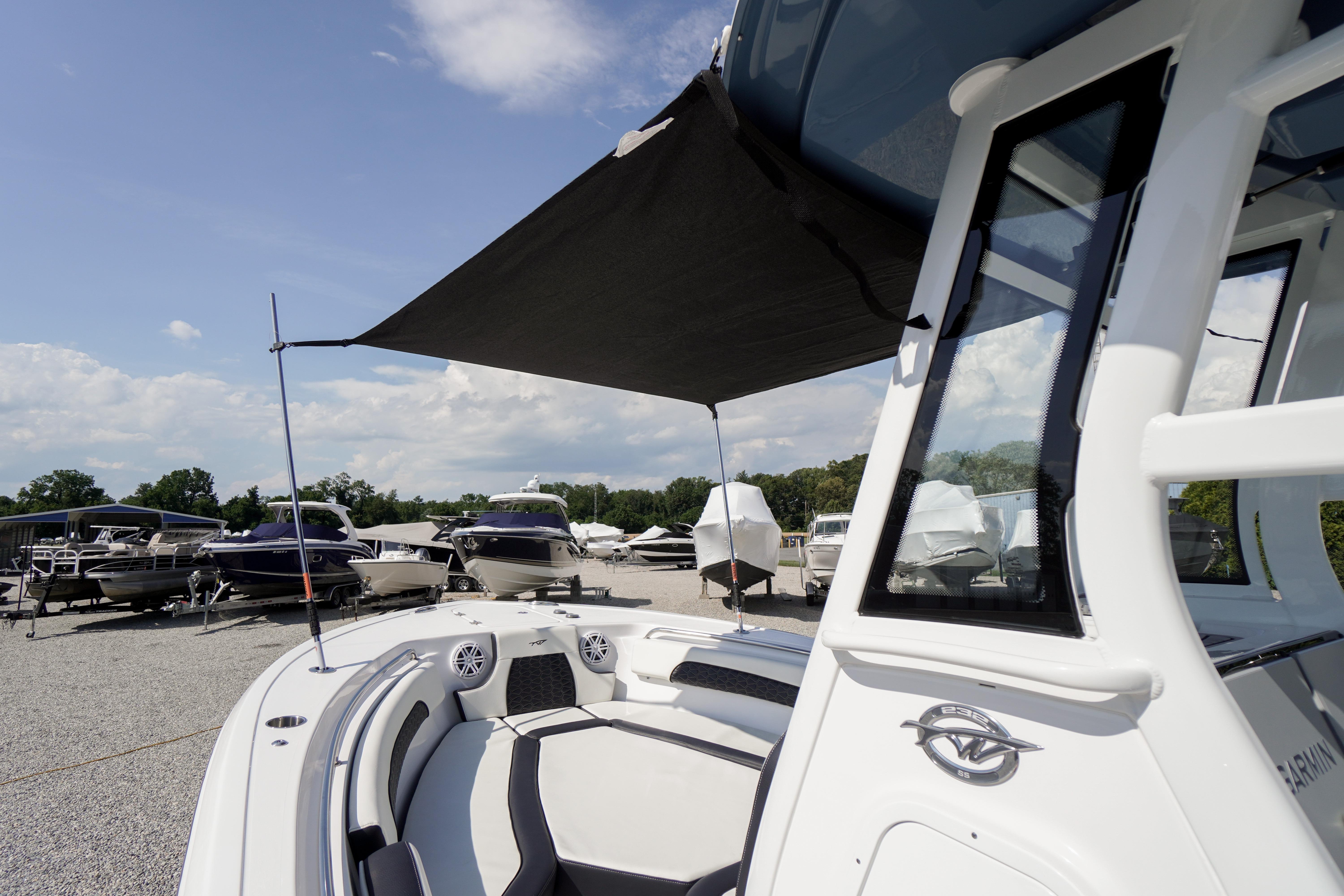 2025 Tidewater 232 SS boat with canopy, displayed in a marina under a clear sky.