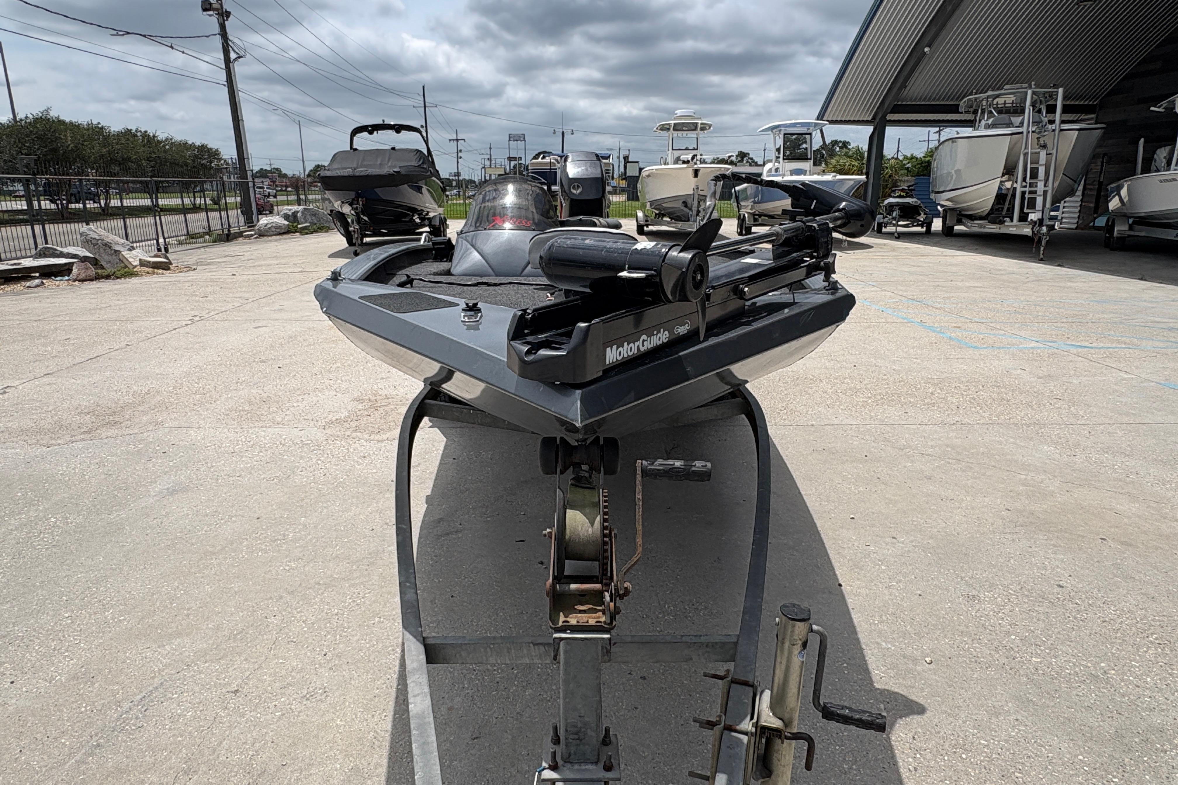 2000 Xpress X18 boat on trailer, parked outdoors under cloudy sky.