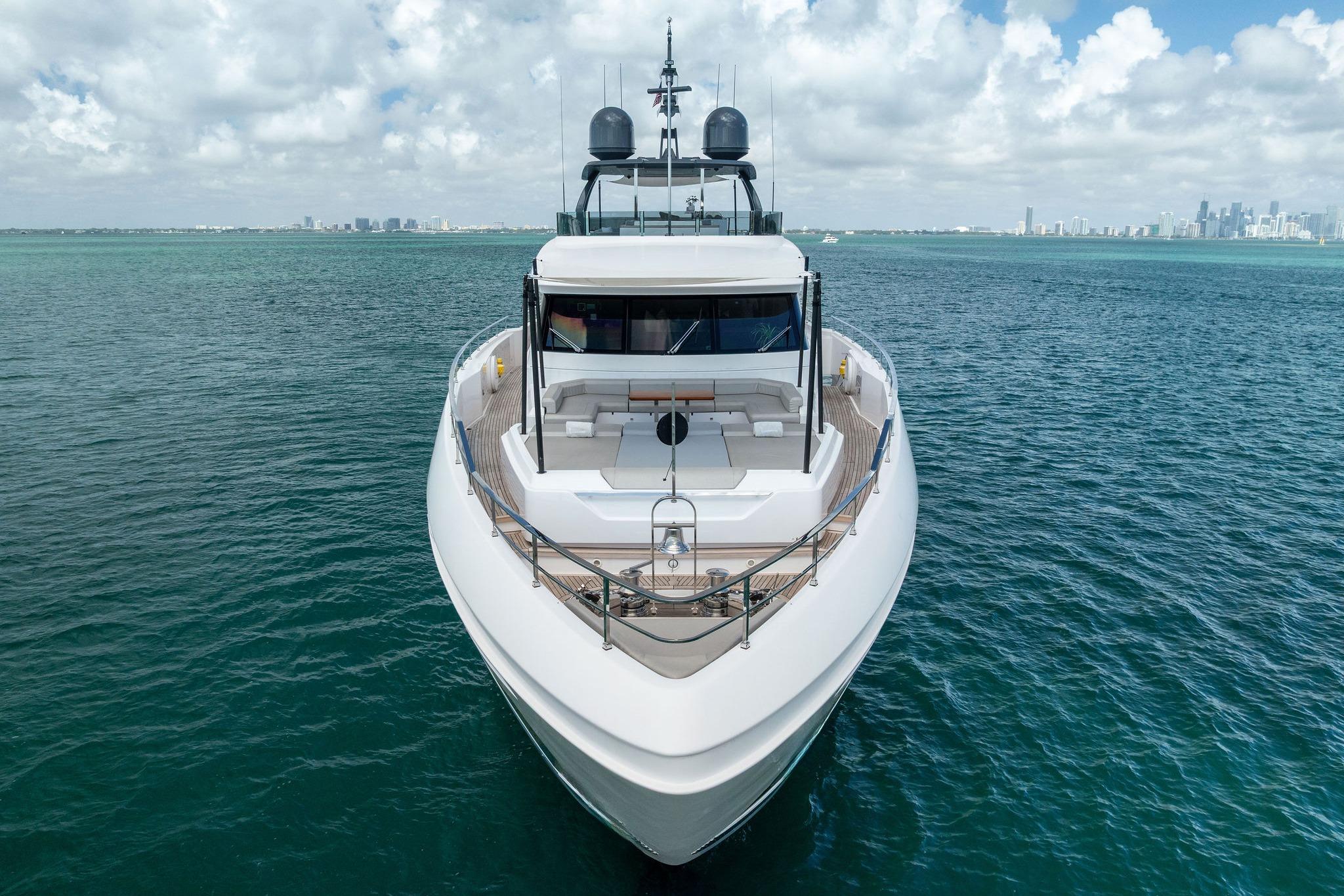 Luxurious 2023 Custom Line Navetta 33 yacht on open sea with city skyline backdrop.