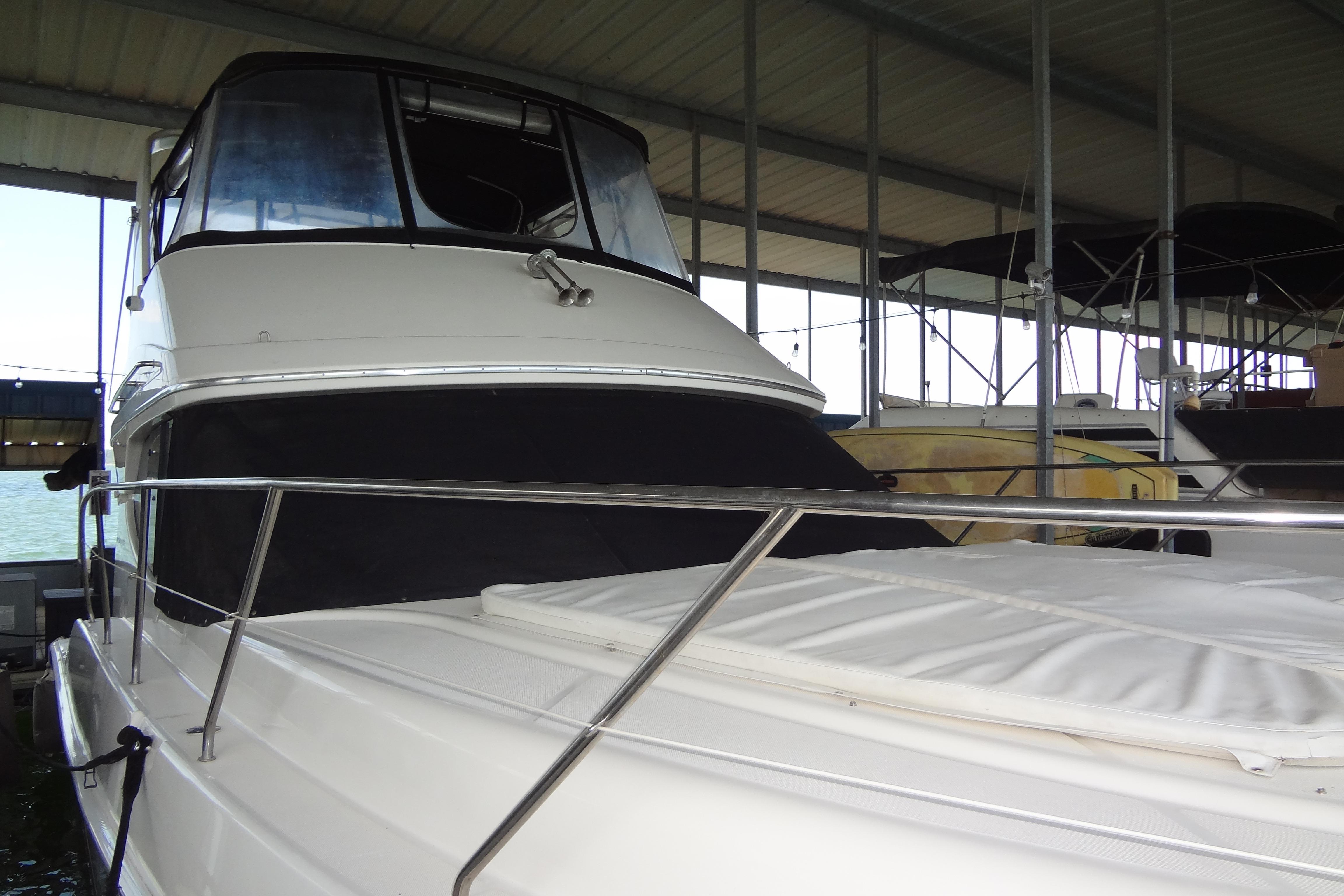 2005 Silverton 34 Convertible yacht docked under a covered marina.