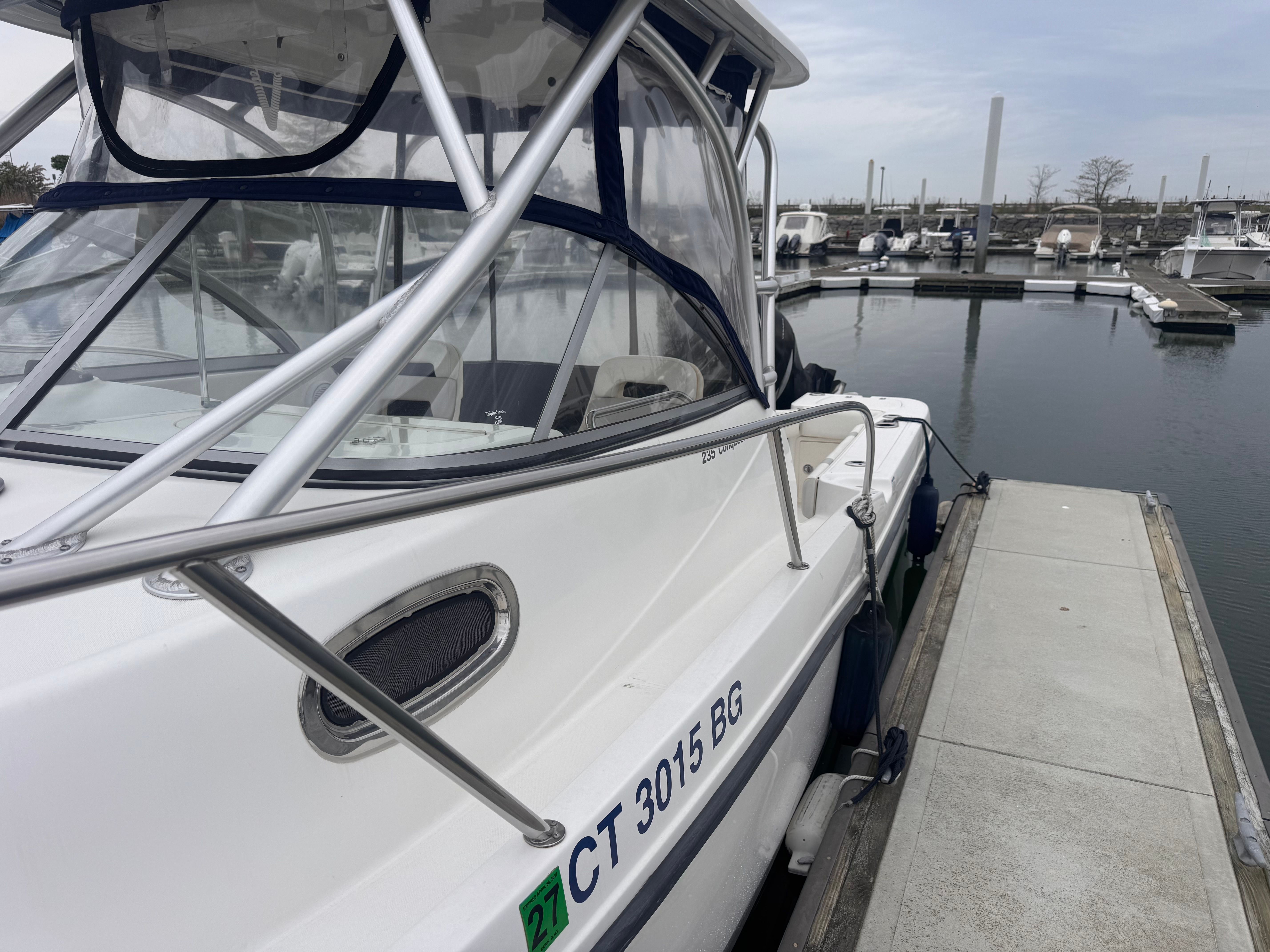 2012 Boston Whaler 235 Conquest docked, side view.