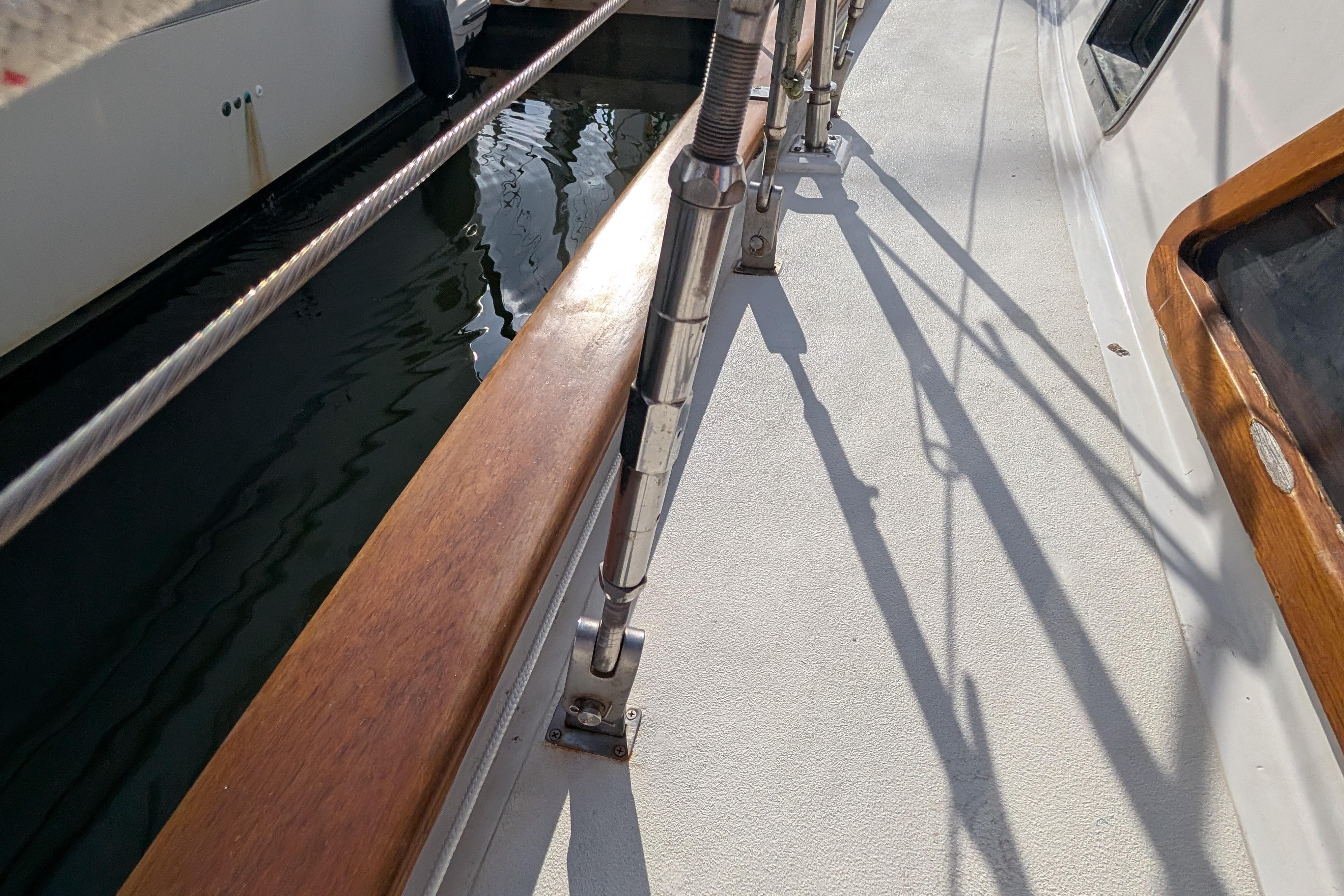 Deck view of a 1983 Robert Perry 41 sailboat, featuring wooden railings and metal rigging.