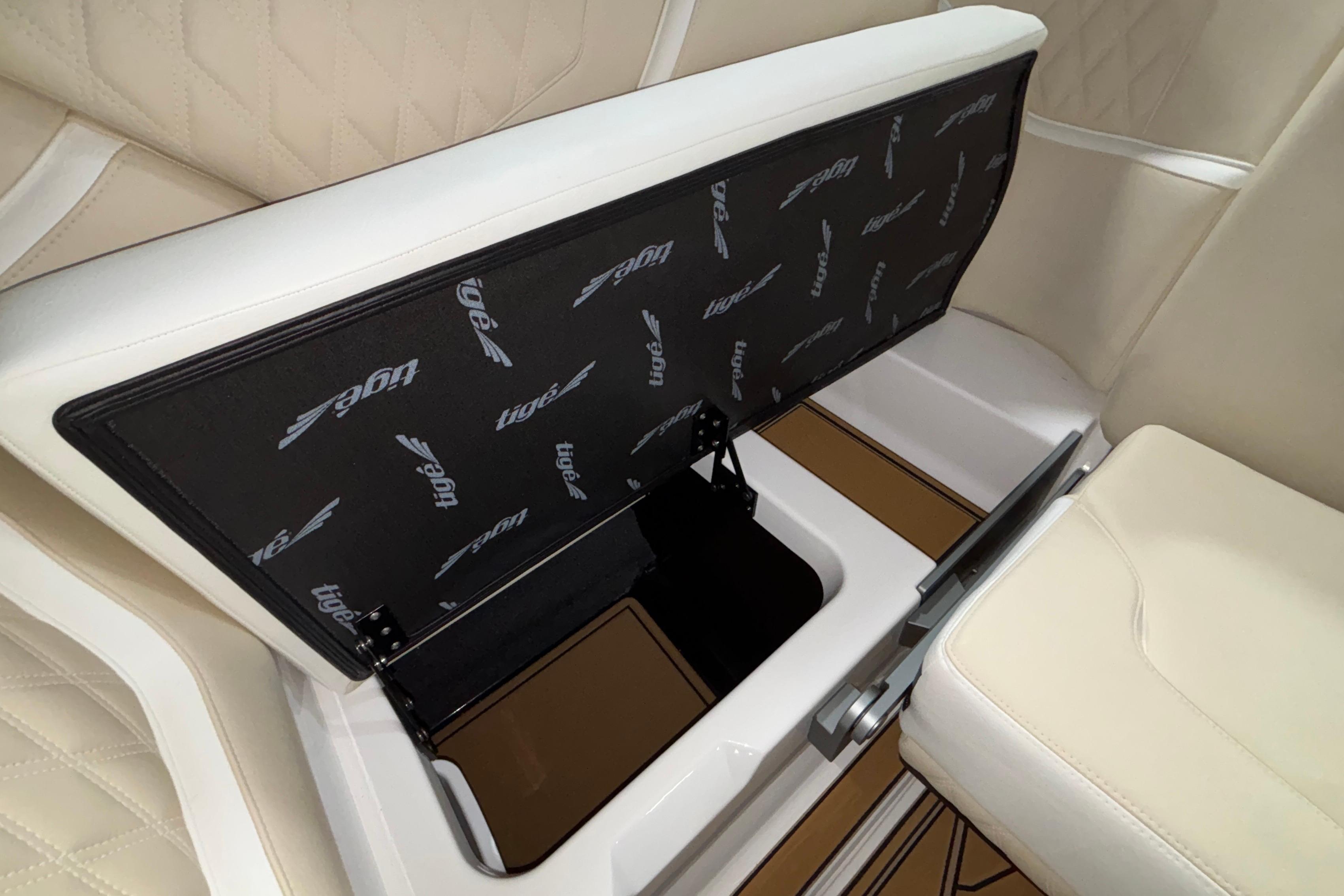 2026 Tigé 22RZX boat interior storage compartment with beige seating and logo detailing.