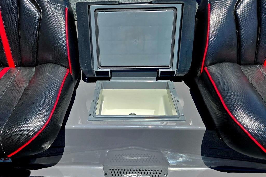 2026 Skeeter ZXE20 boat interior with open storage compartment between black and red seats.