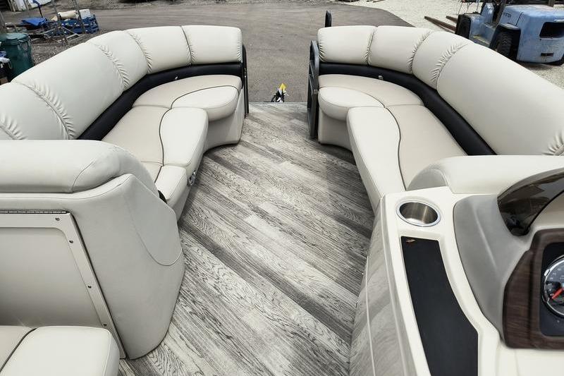 Luxurious seating on a 2017 Manitou 25 Oasis SE pontoon boat with elegant wood flooring.