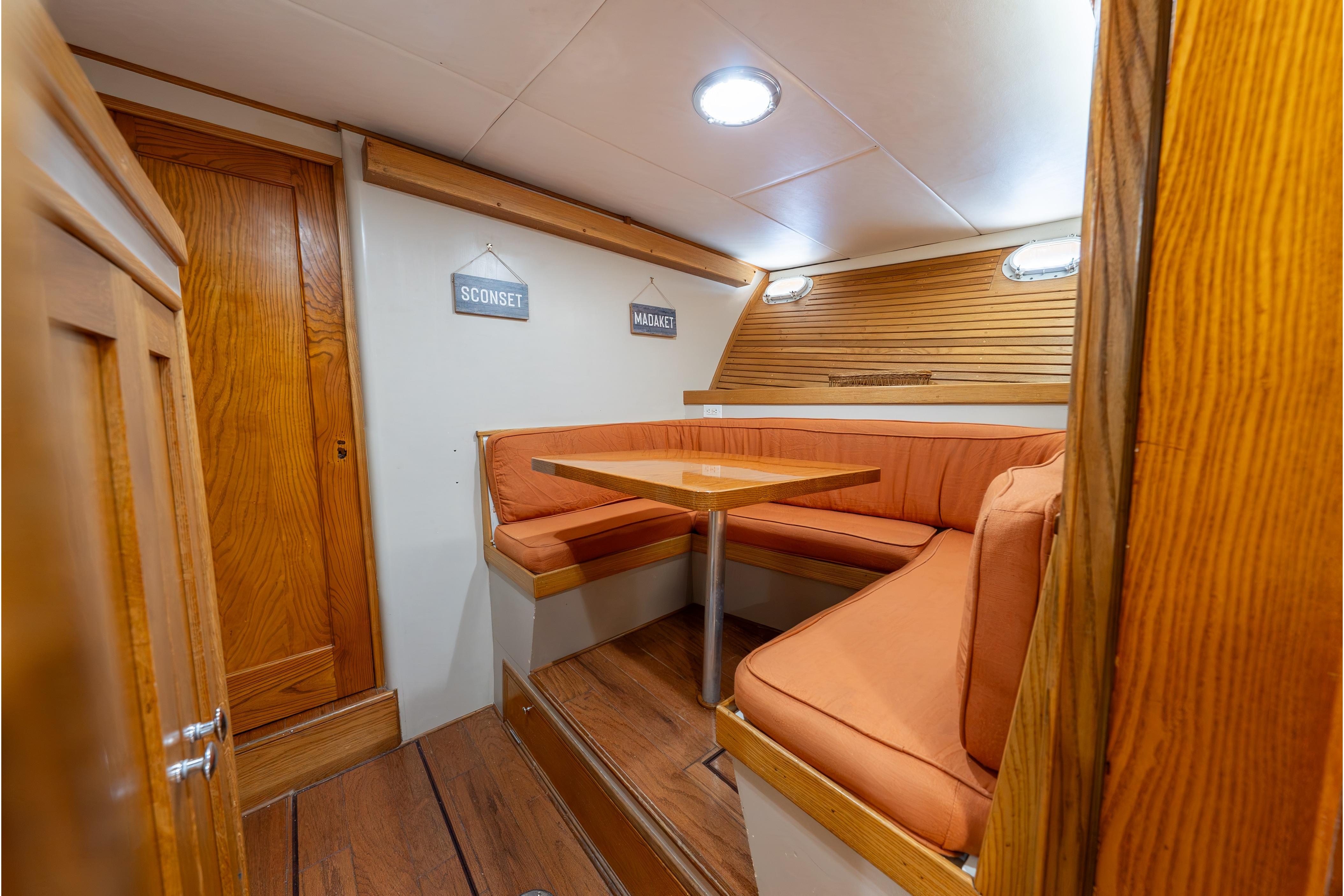 1963 Trumpy Classic yacht interior with cozy dining area and wooden accents.