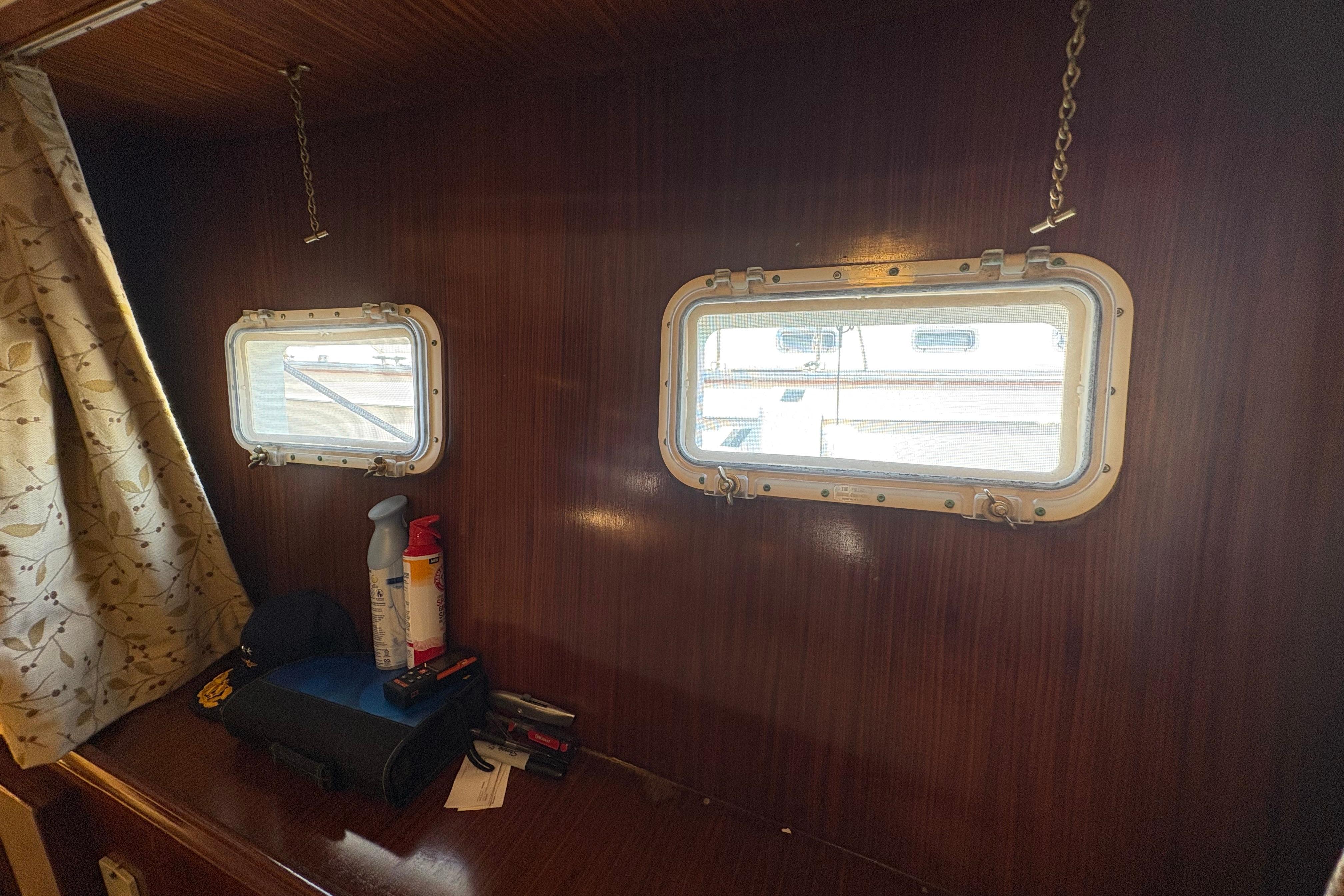 Interior of 1985 Hatteras 60 Convertible yacht with portholes and wooden paneling.