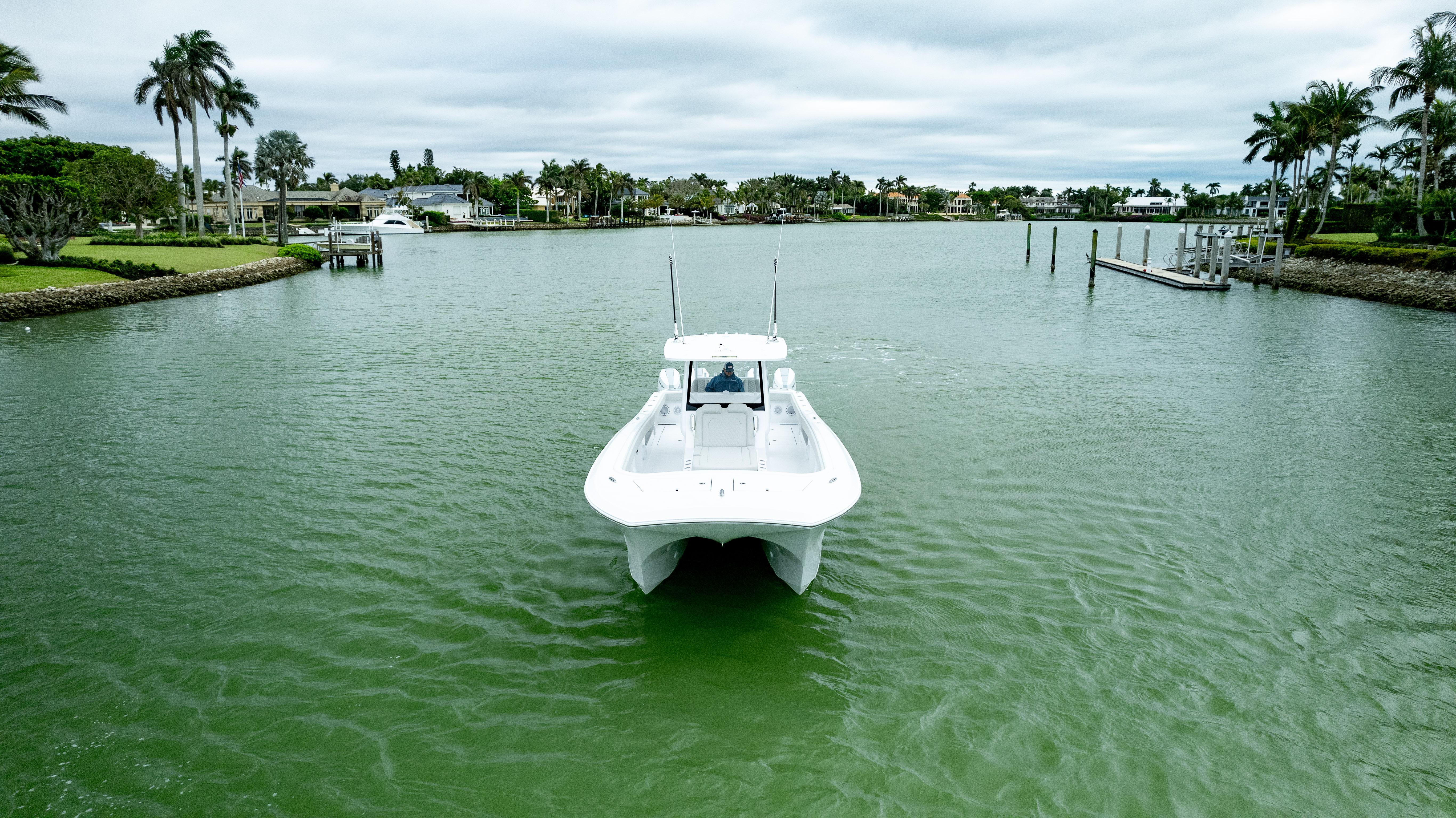 Front Runner 37 Catamaran 2025 cruising on a serene waterway with lush greenery.