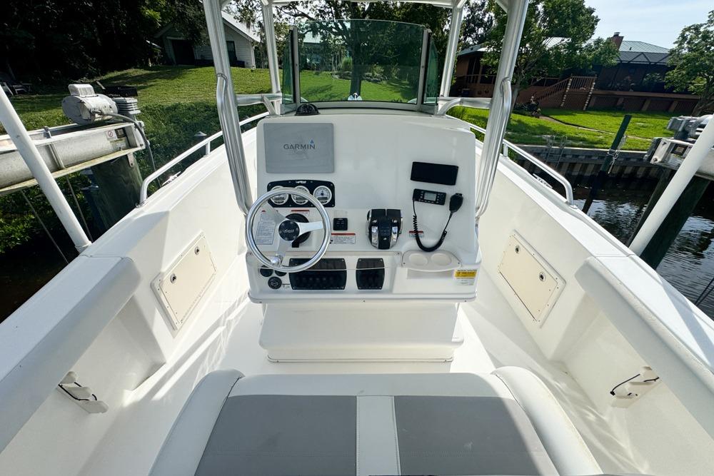 2018 Mako 284 Center Console boat interior with steering wheel and navigation equipment.