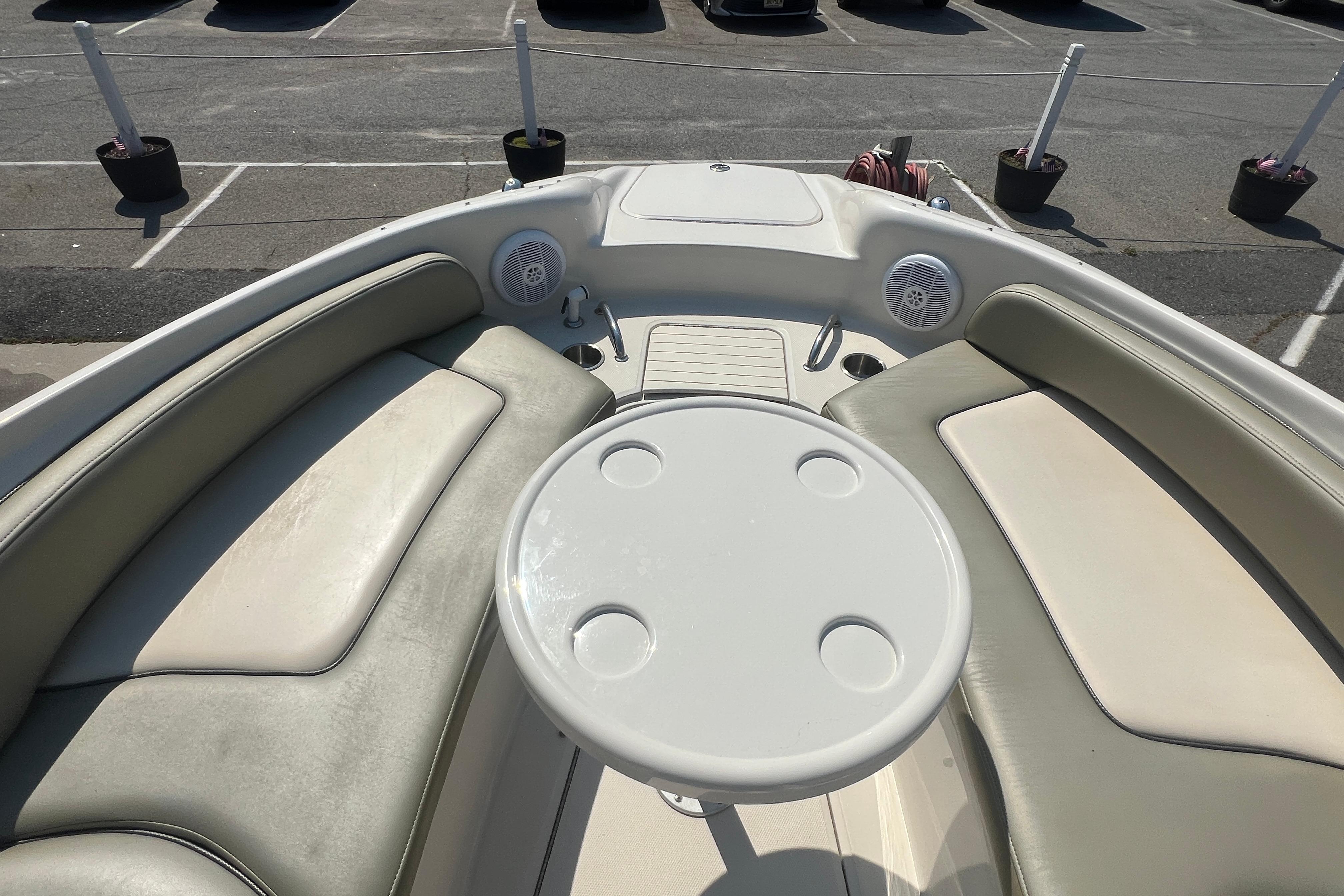 2005 Sea Ray 240 Sundeck boat interior with cushioned seating and round table.