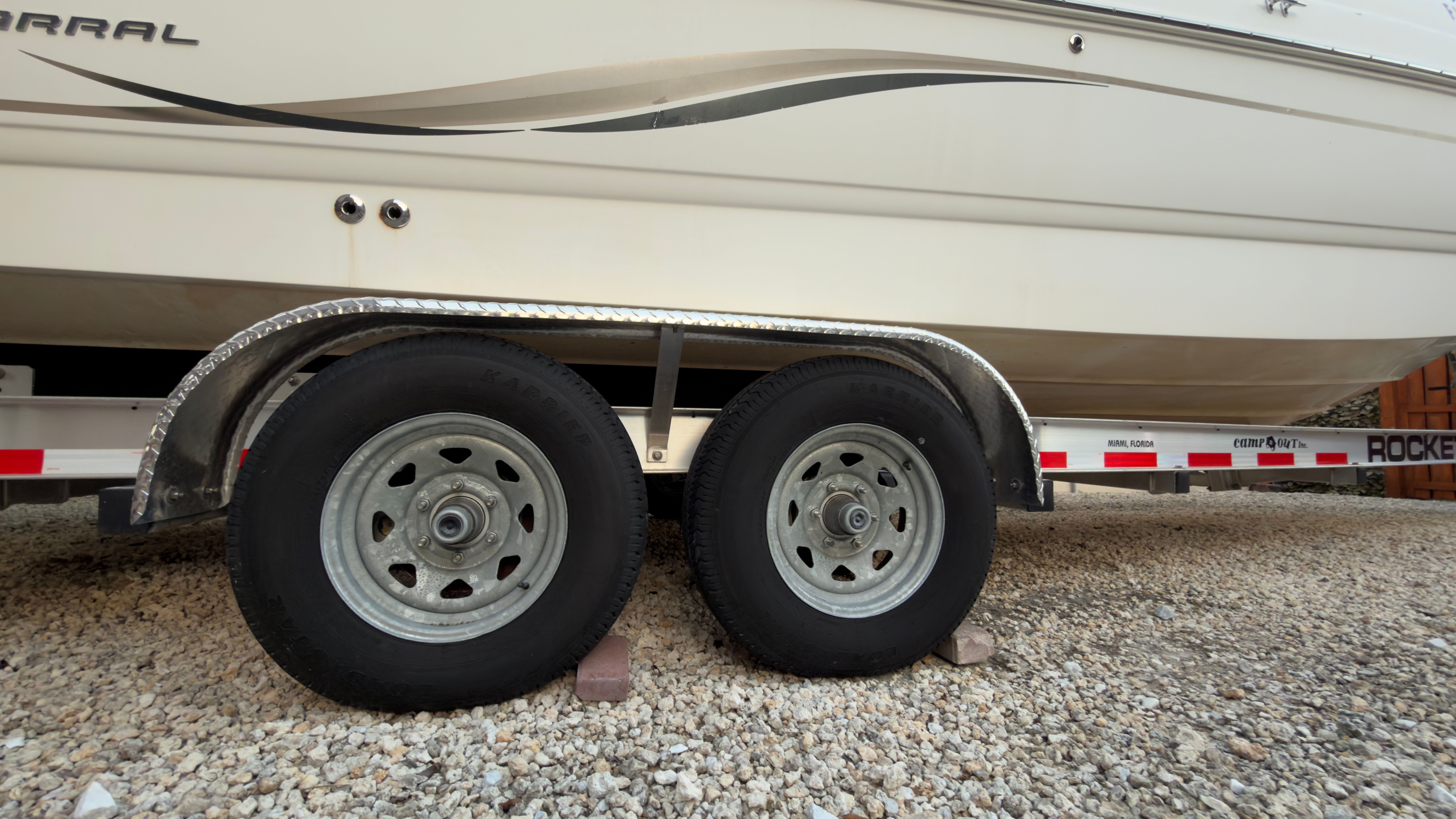 2003 Chaparral 263 Sunesta Deckboat on trailer, close-up of wheels.