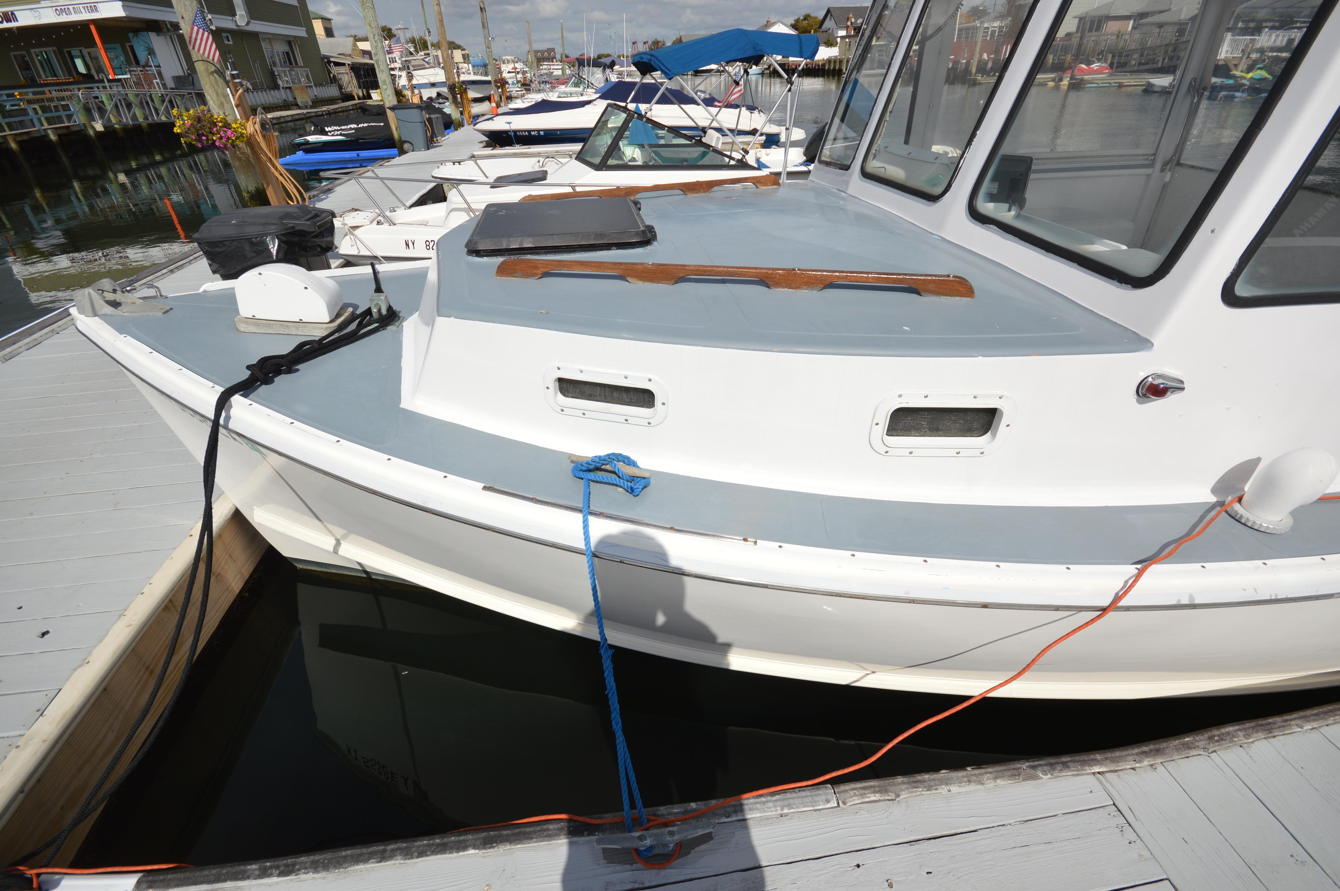 1983 BHM 25 EXPRESS boat docked at marina, featuring white and gray exterior.