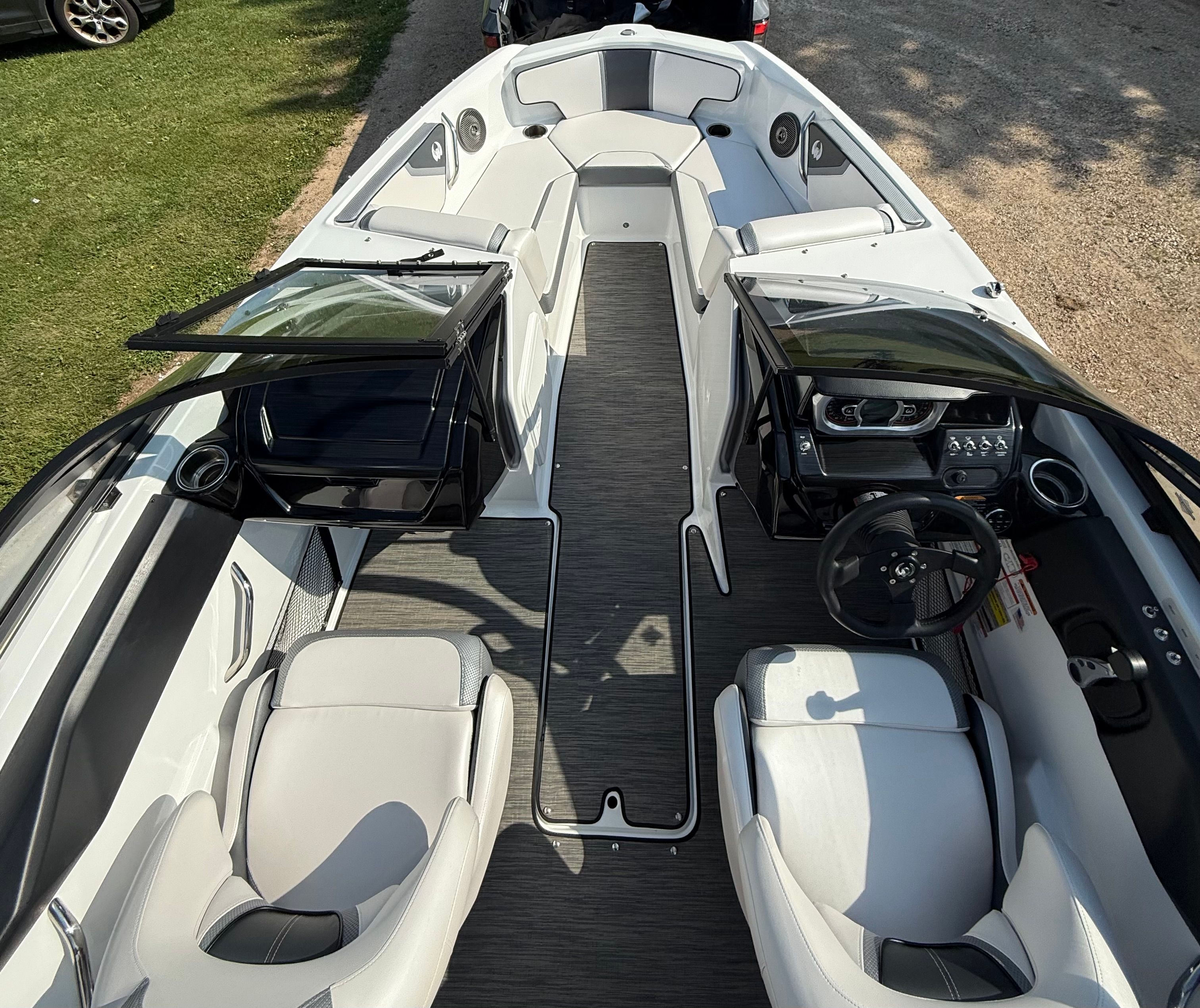 The image shows the cockpit of a 2023 Scarab 195 ID boat with modern seating and controls.