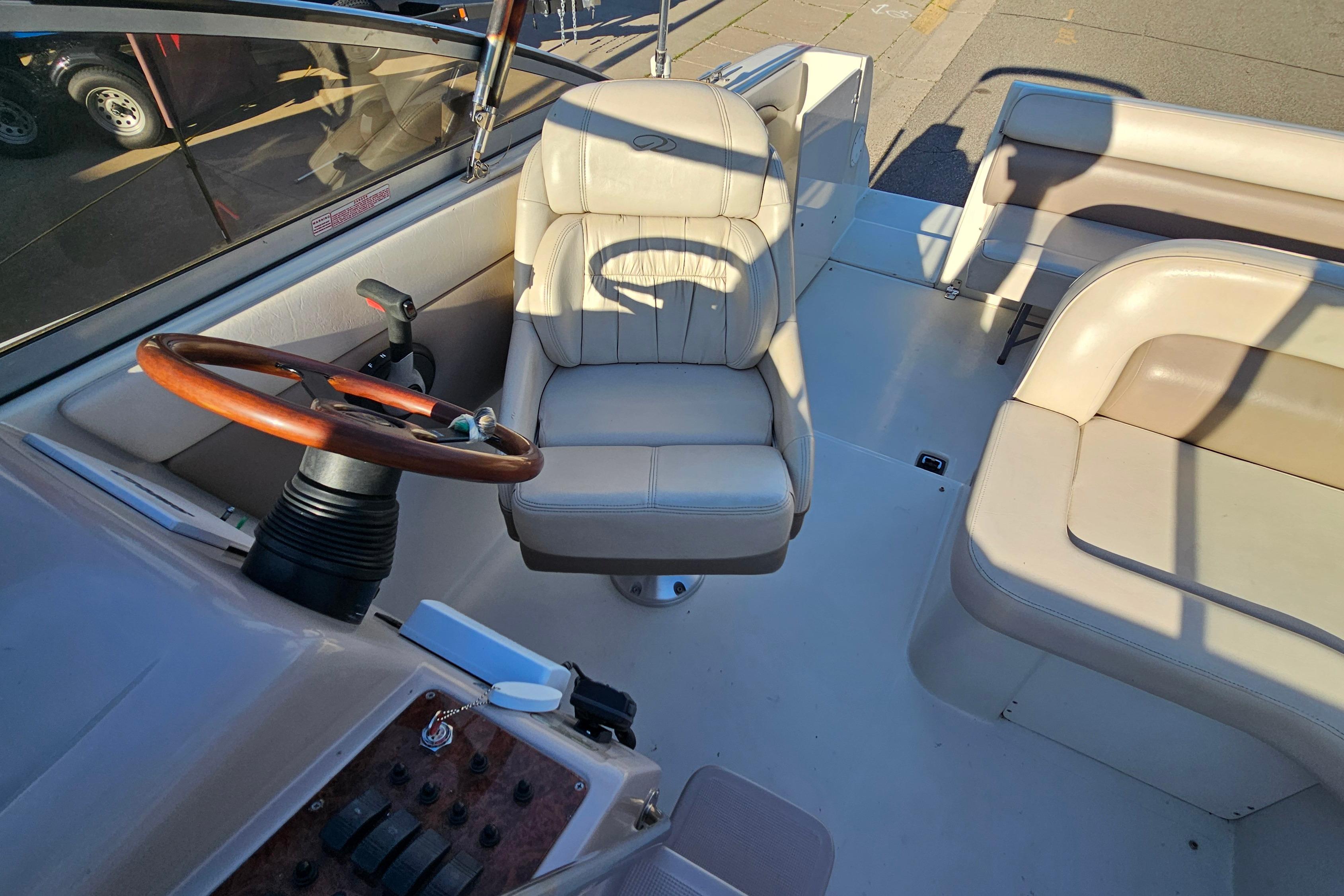 1999 Regal Commodore 258 boat interior with steering wheel and beige seating.
