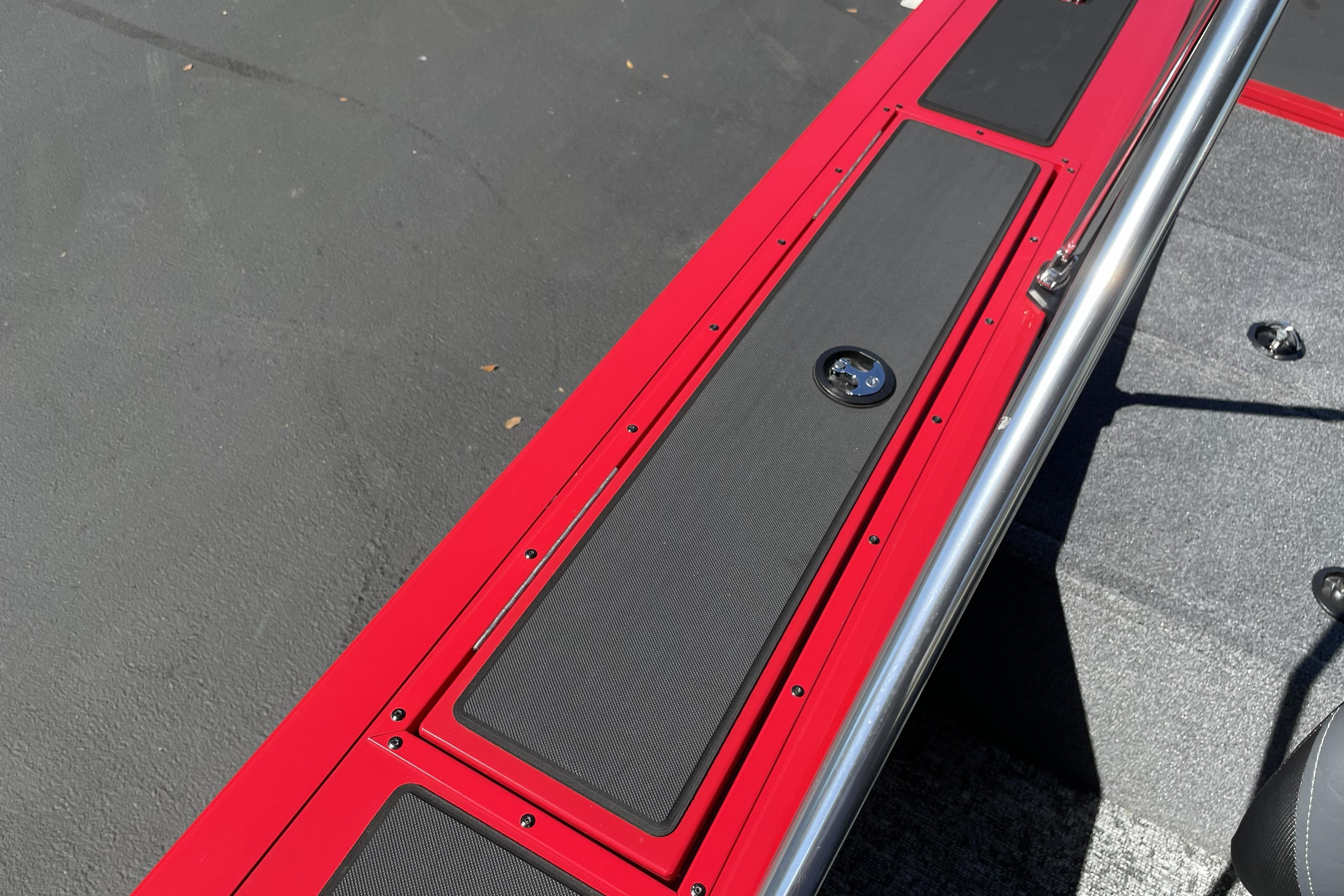 Red and black deck of 2026 Tracker Targa V-18 WT boat with metal railing.