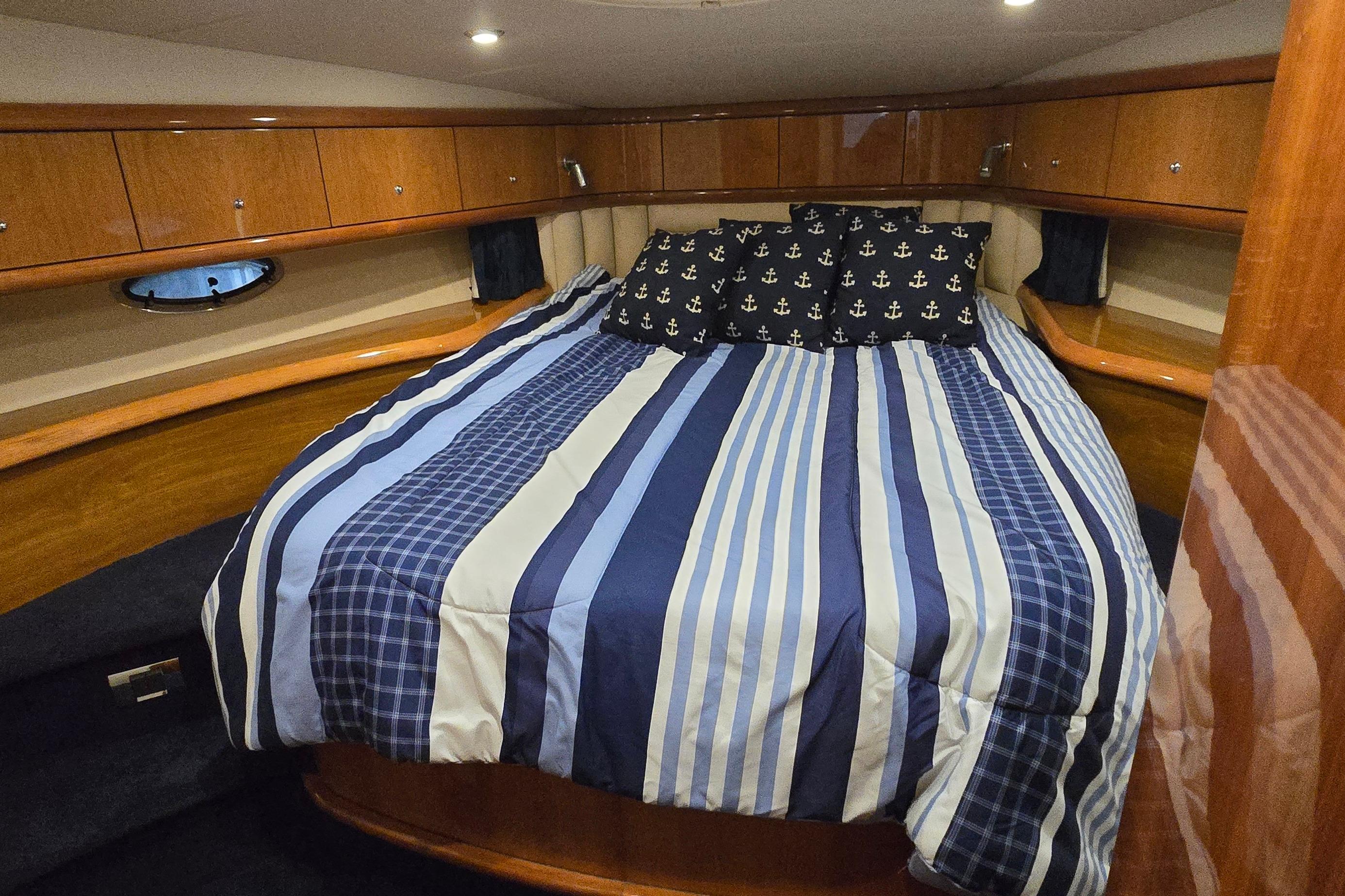 Luxurious cabin interior of 2004 Sunseeker Camargue 50 yacht with striped bedding.