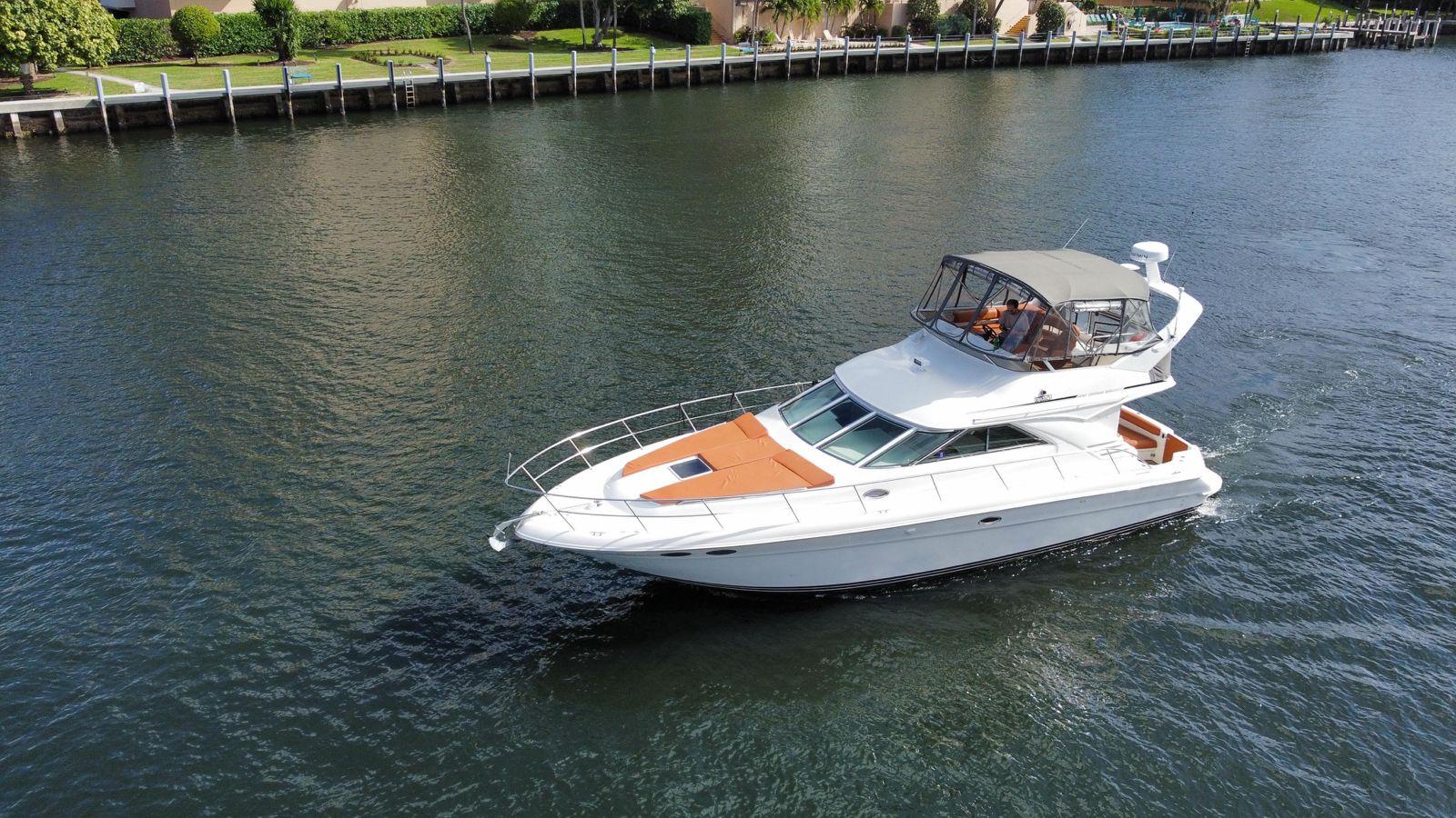 1997 Sea Ray 400 Sedan Bridge yacht cruising on a calm waterway.
