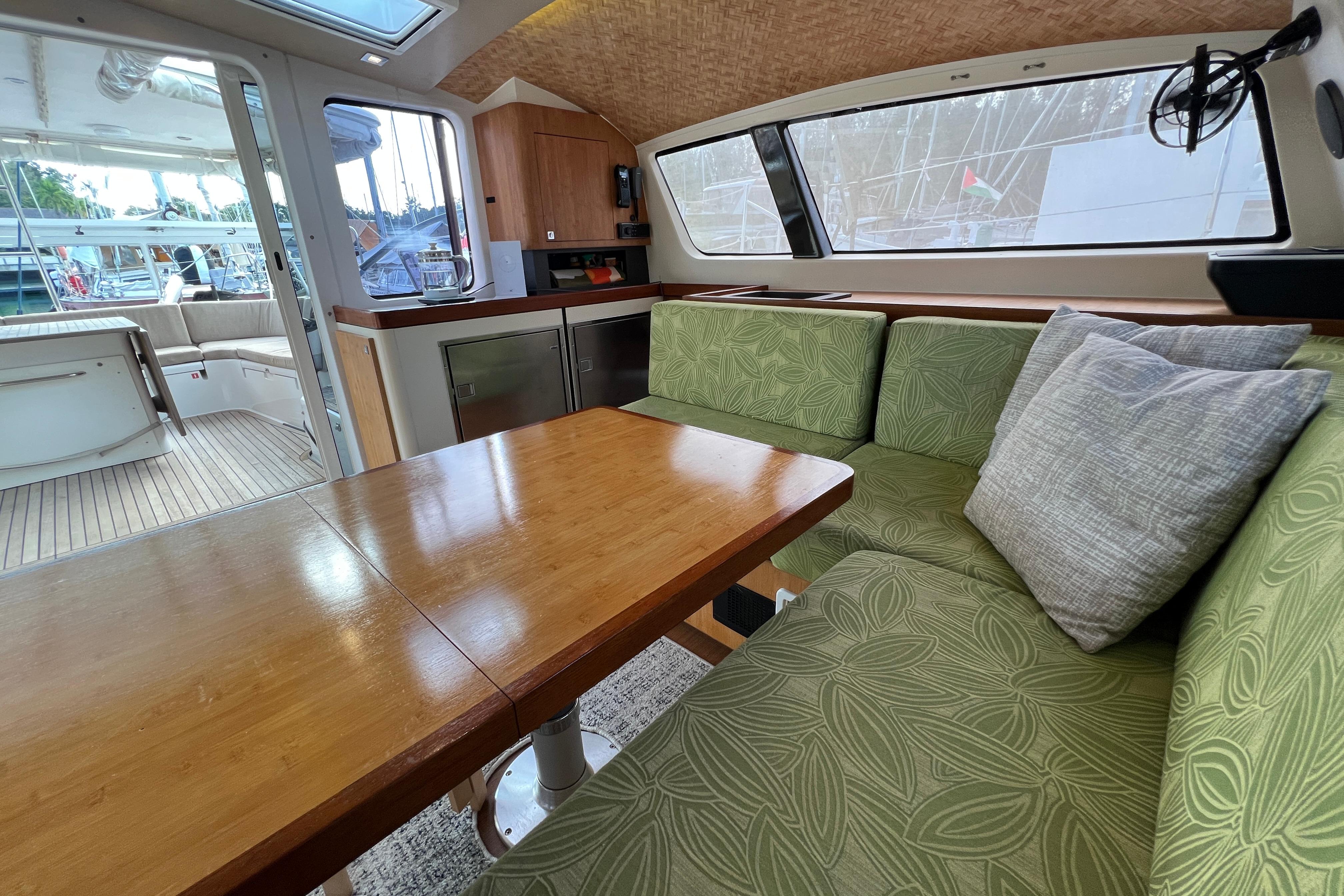 Interior of 2015 Outremer 51 yacht with green seating and wooden table.