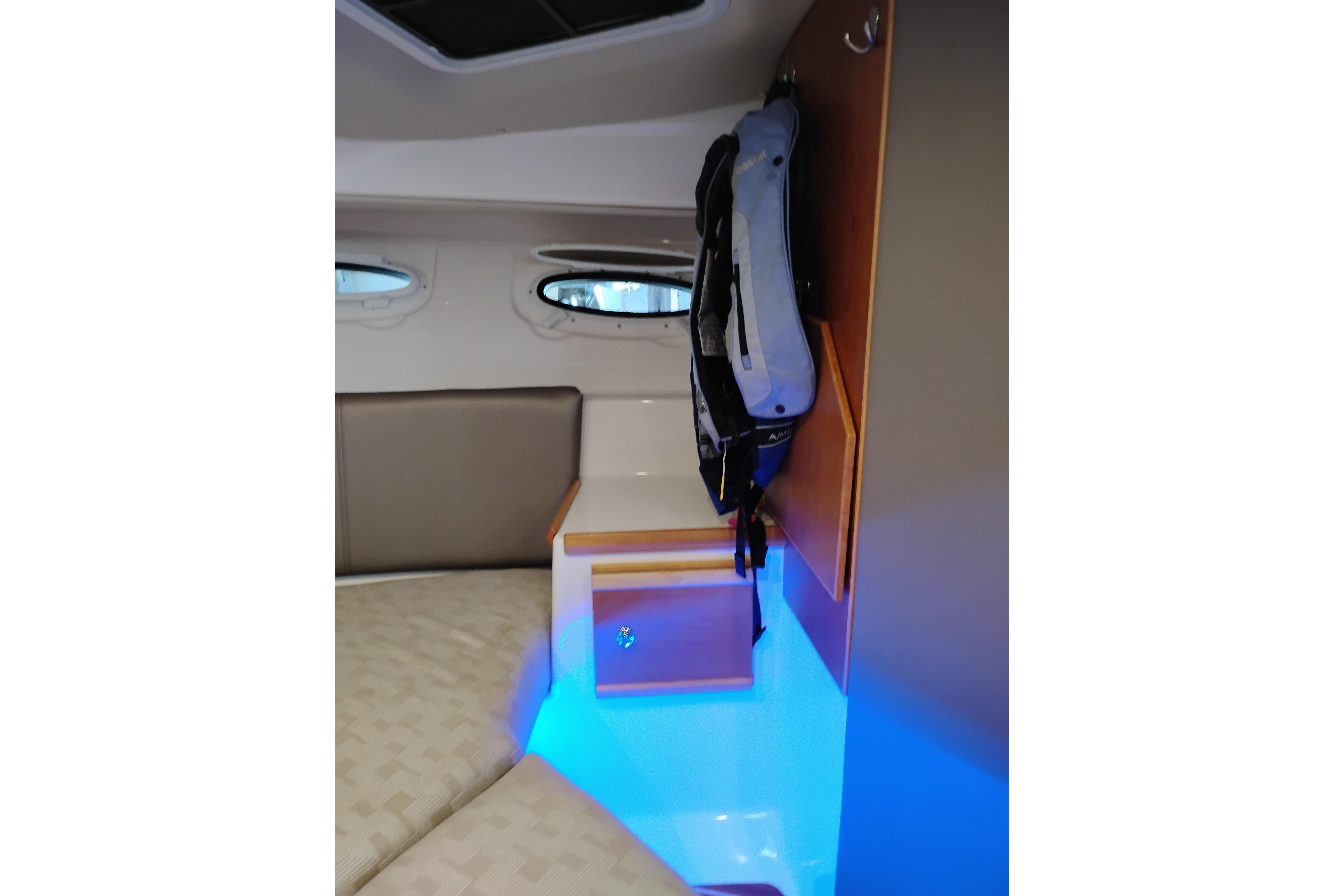 2022 Cutwater C-32 Coupe interior with blue LED lighting and storage cabinet.