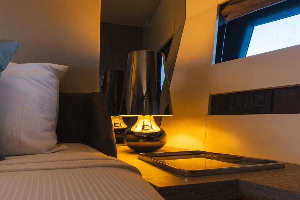 Luxurious interior of 2020 Azimut 60 yacht with elegant bedside lamp and modern decor.