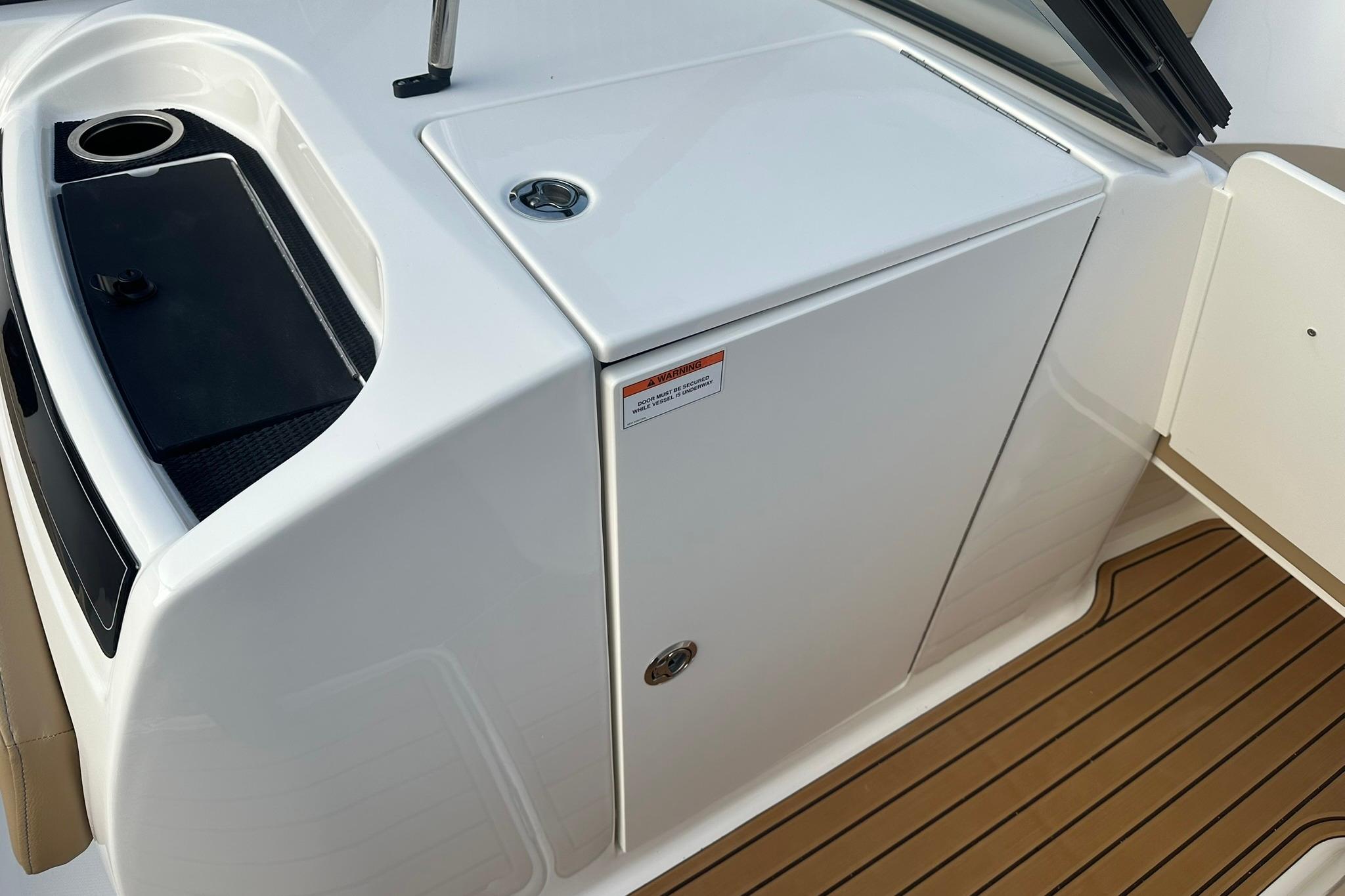 2026 Bayliner VR6 Bowrider OB interior with sleek white cabinetry and wood-textured flooring.